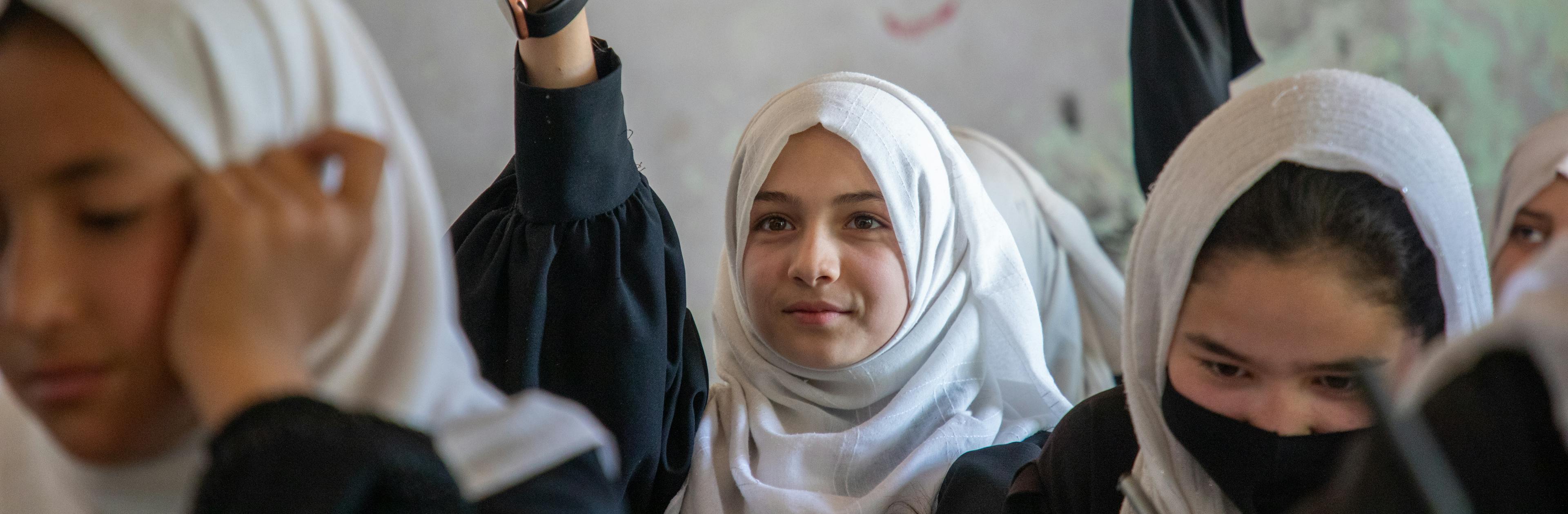 Primary school students in Kabul interact with other students and teachers.