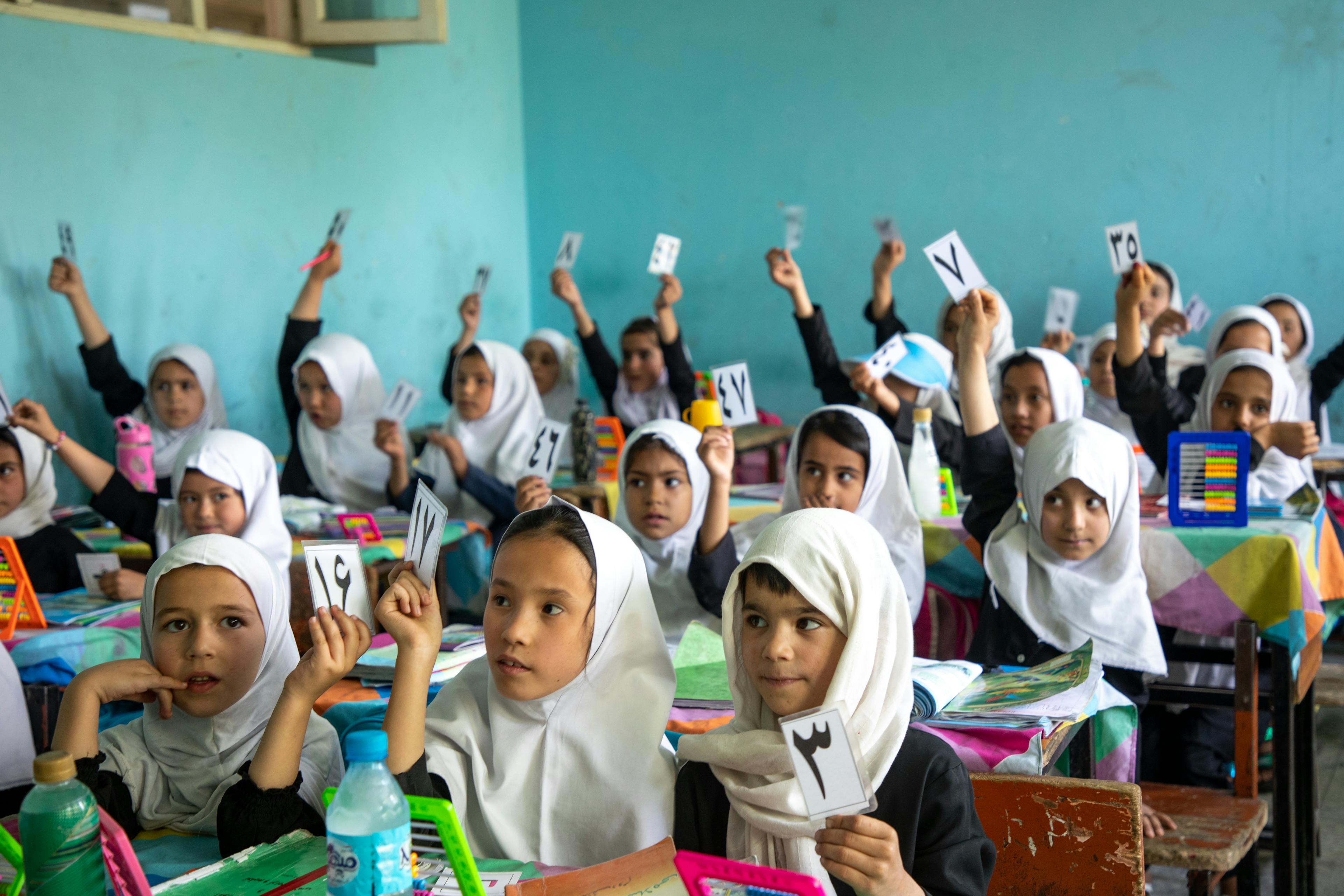 Primary school students in Kabul interact with other students and teachers.