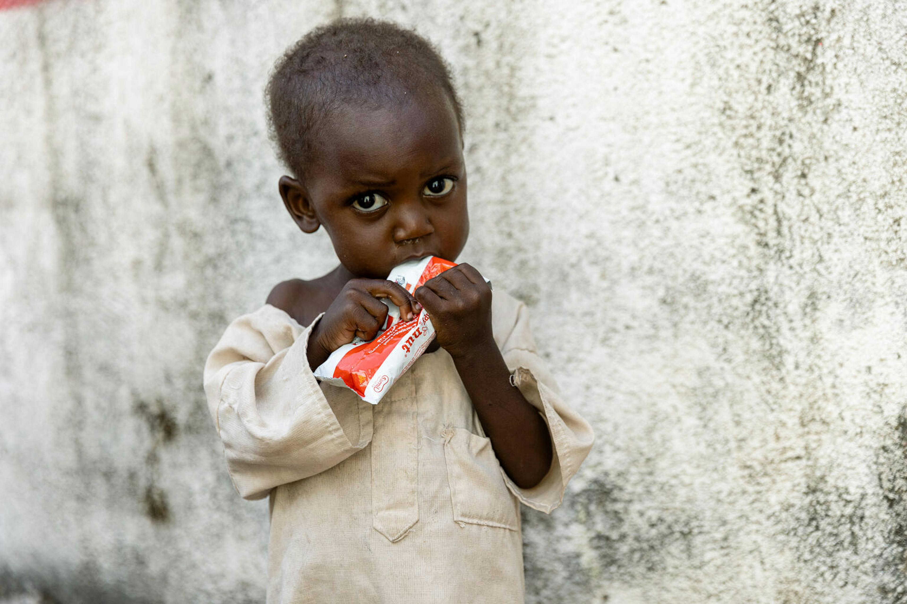A child eats ready-to-use therapeutic food (RUTF) during a nutrition screening at Alnahda Health Centre in Nyala, Sudan.