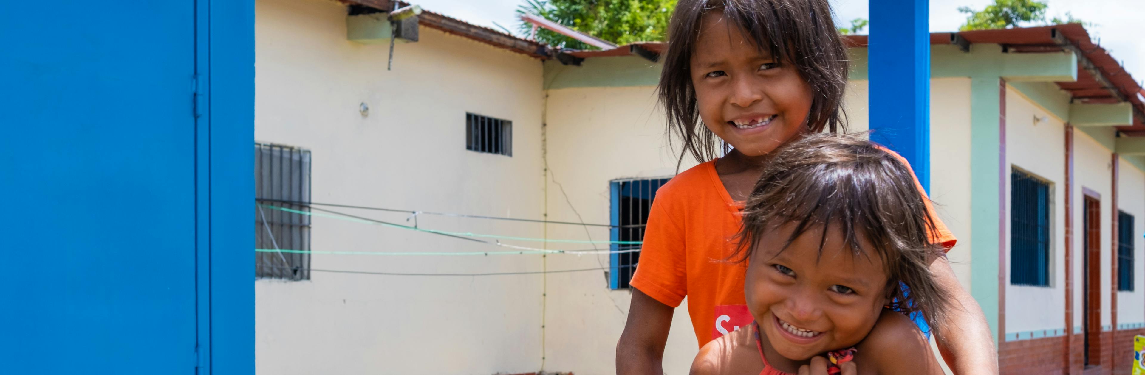 Two young girls outside the Solar Drinking Plant installed in the community of San Francisco de Guayo, Delta Amacuro state, Venezuela