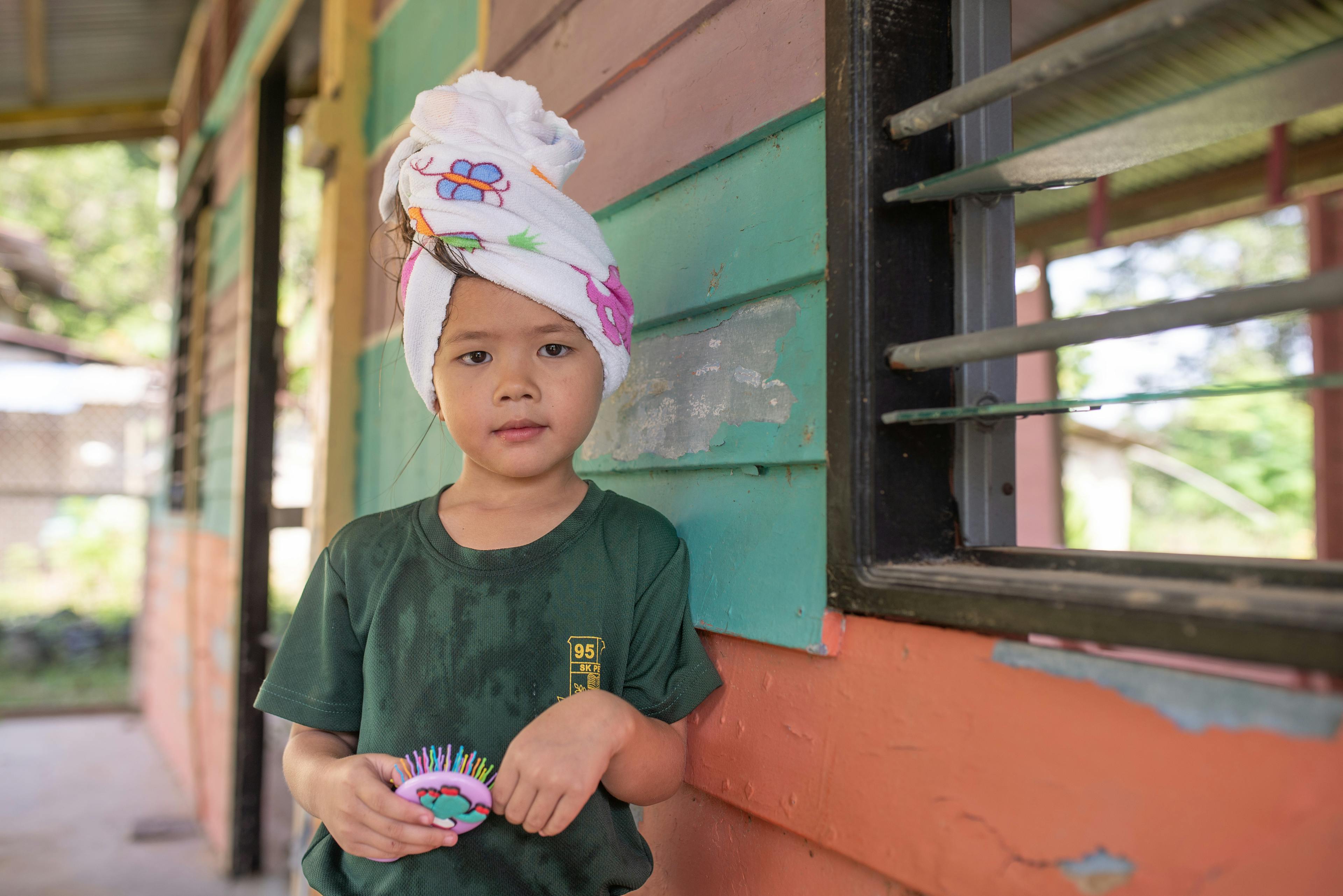 Qaira Nuraisya (6) posing for a photograph after received a hair care session during a mobile health clinic program organized by the Mersing District Health Office at her kindergarten. The hair care session is part of education on personal hygiene to indigenous community in Mersing, Johor.