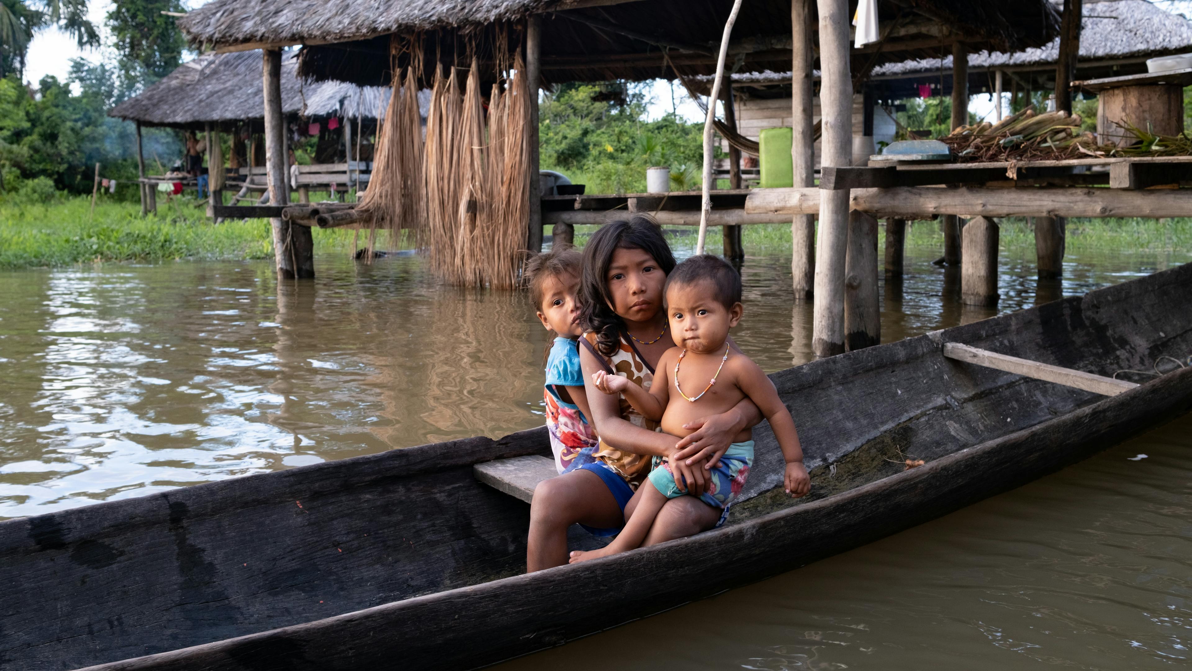 Children and families of the Warao indigenous community living in the surrounding communities approach in their curiara to receive water containers to collect safe water from the solar water treatment plant installed in San Francisco de Guayo, Delta Amacuro state, Venezuela.