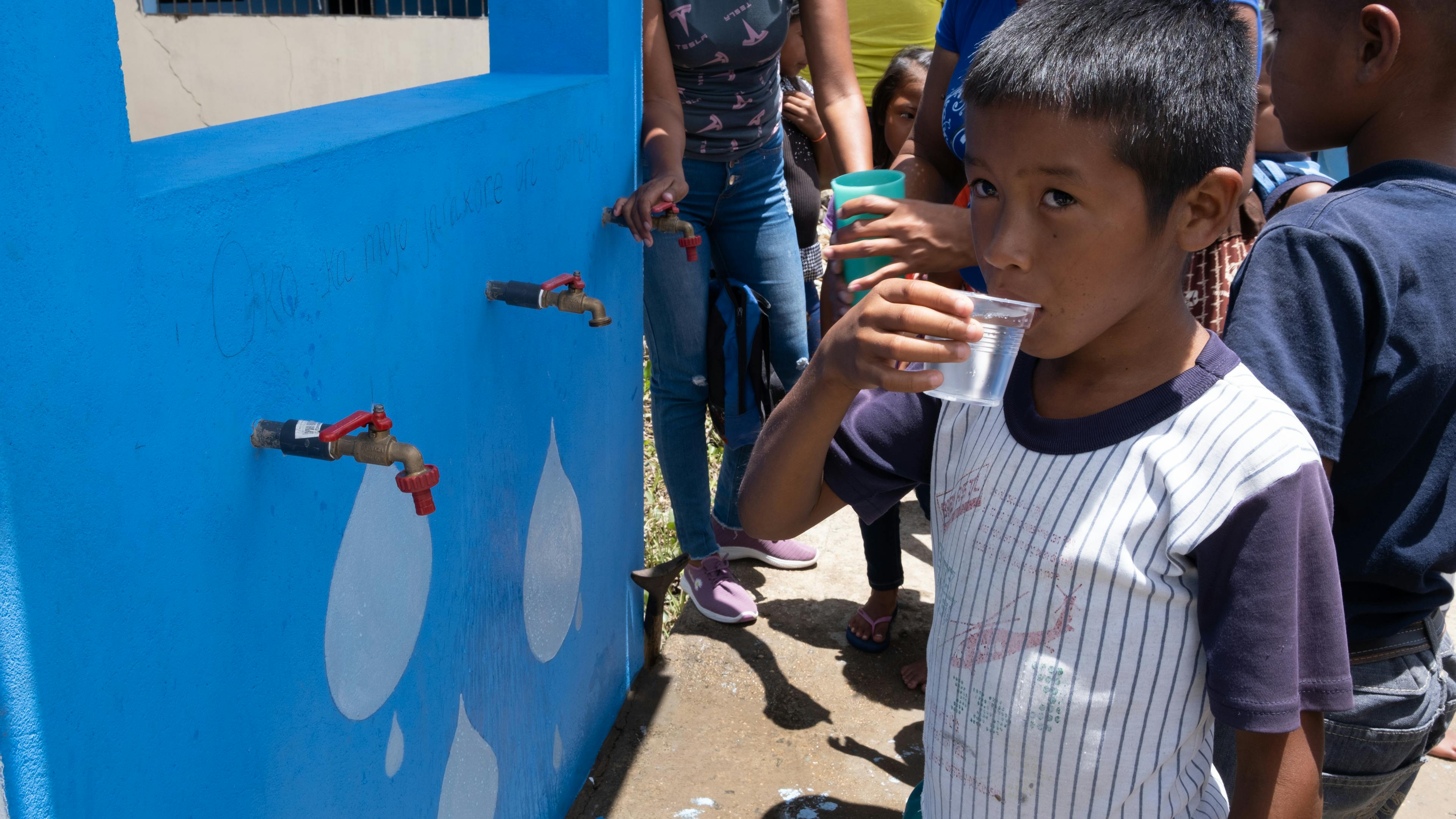 A child drinking safe tap water from solar-powered drinking plant in San Francisco de Guayo, Delta Amacuro state, Venezuela.