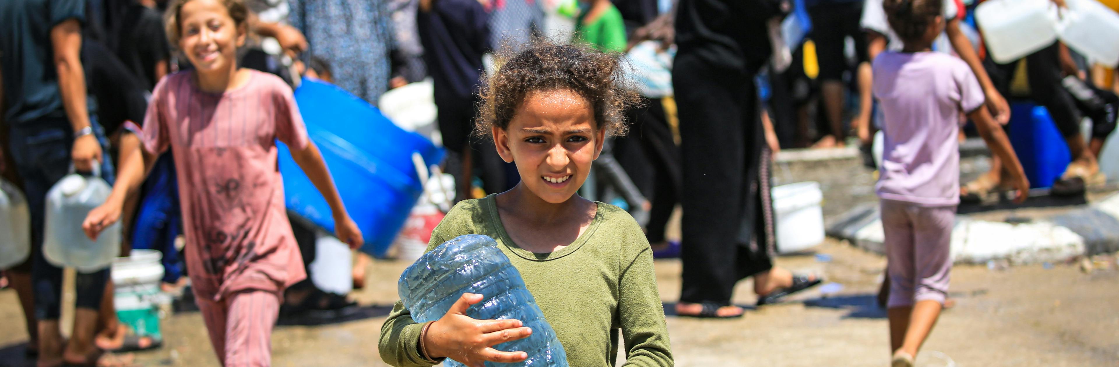 Mariam, 10-year-old, holding a bottle of water after she filled from a UNICEF-supported water tank in Deir al-Balah, in the Gaza Strip.