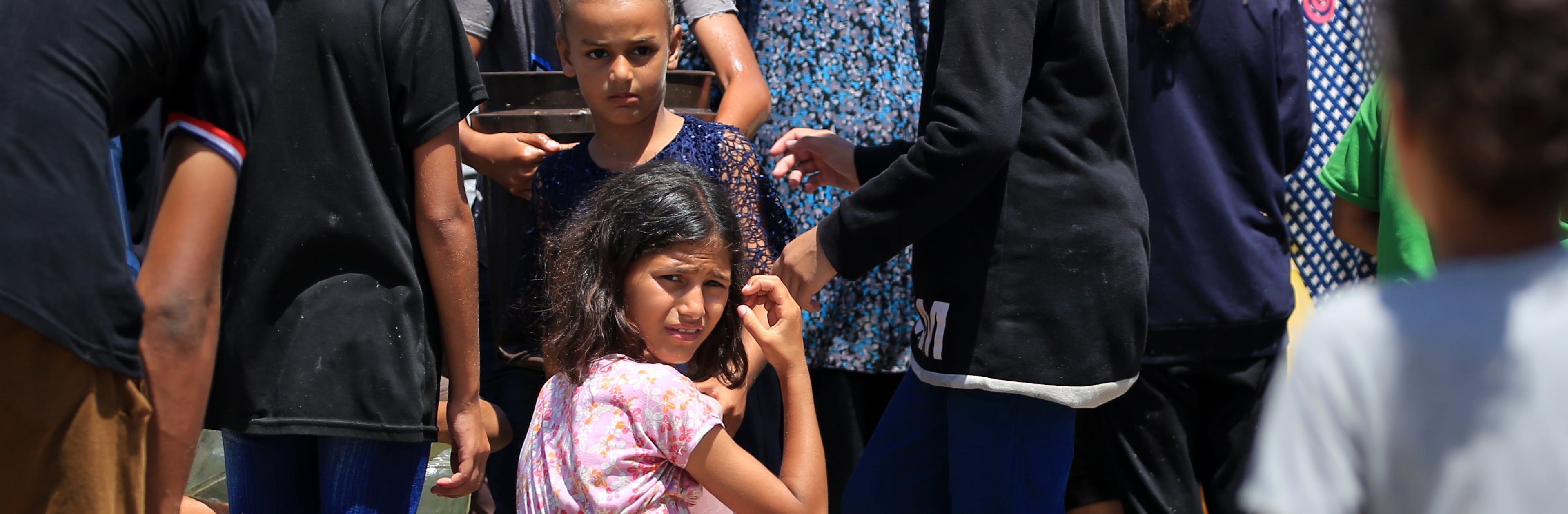 Children and their families fetching water from a UNICEF-supported water tank in Deir al-Balah, in the Gaza Strip.