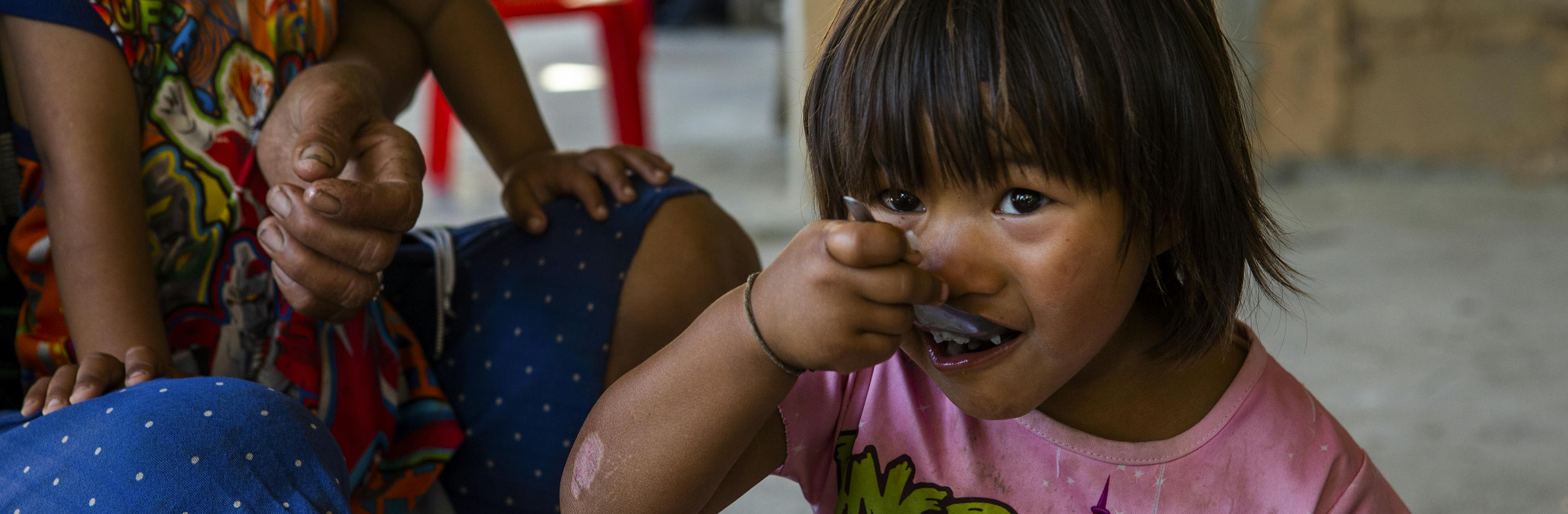 4-year-old Ma Mi Dawt enjoys a nutritious meal. Eastern Shan state of Myanmar.