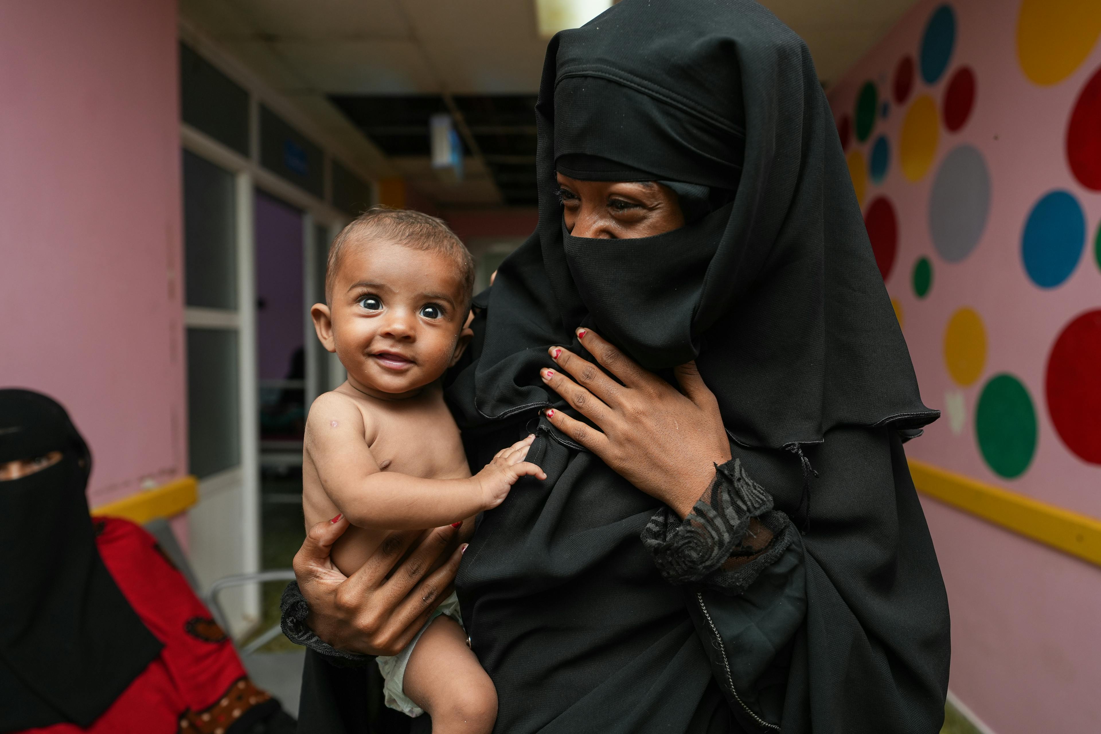 Little Sanad in the arms of his mother.