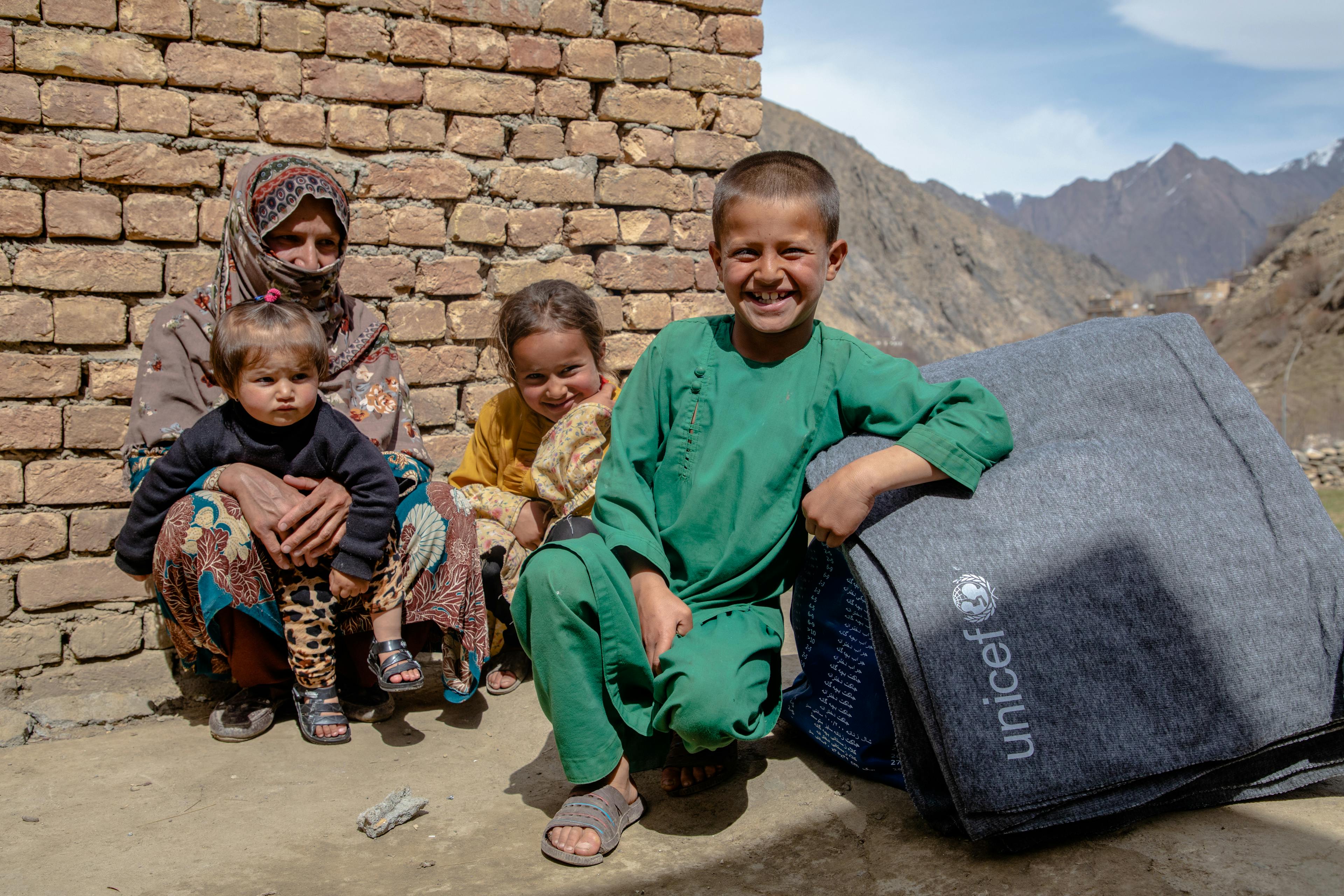 Razia and her six children open a winter clothing kit in Panjshir Province, Afghanistan. Razia was grateful for the winter clothes, but she is also worried about her children's health. At the time of this visit, one of her sons was sick with pneumonia and in Kabul with his grandparents.