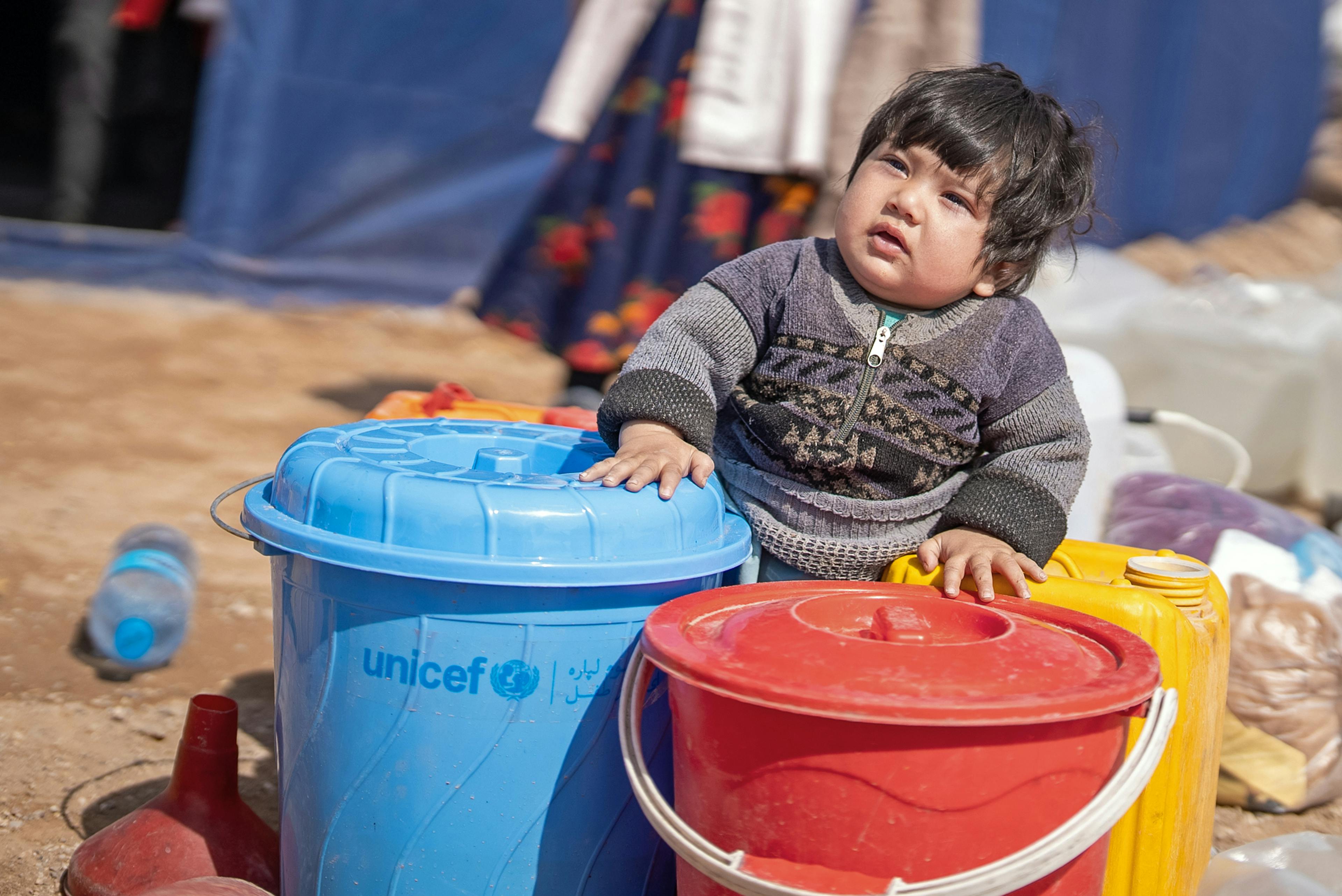 2 year old Mohammed sits with a water bucket provided by UNICEF in Koshkak village, Zinda Jan District, western Afghanistan.