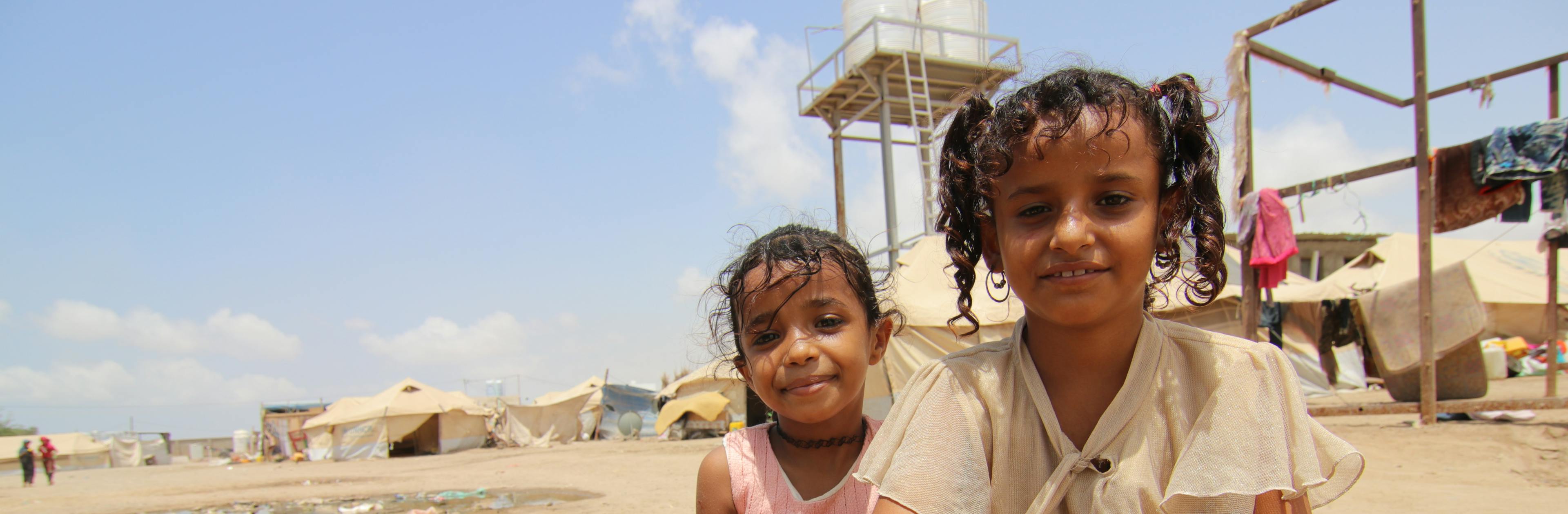 In Yemen, Muna Zayed (right), 10, and her friend, Rahf, fill a jerry can at a water point in the Al Sha’ab camp in Aden. 