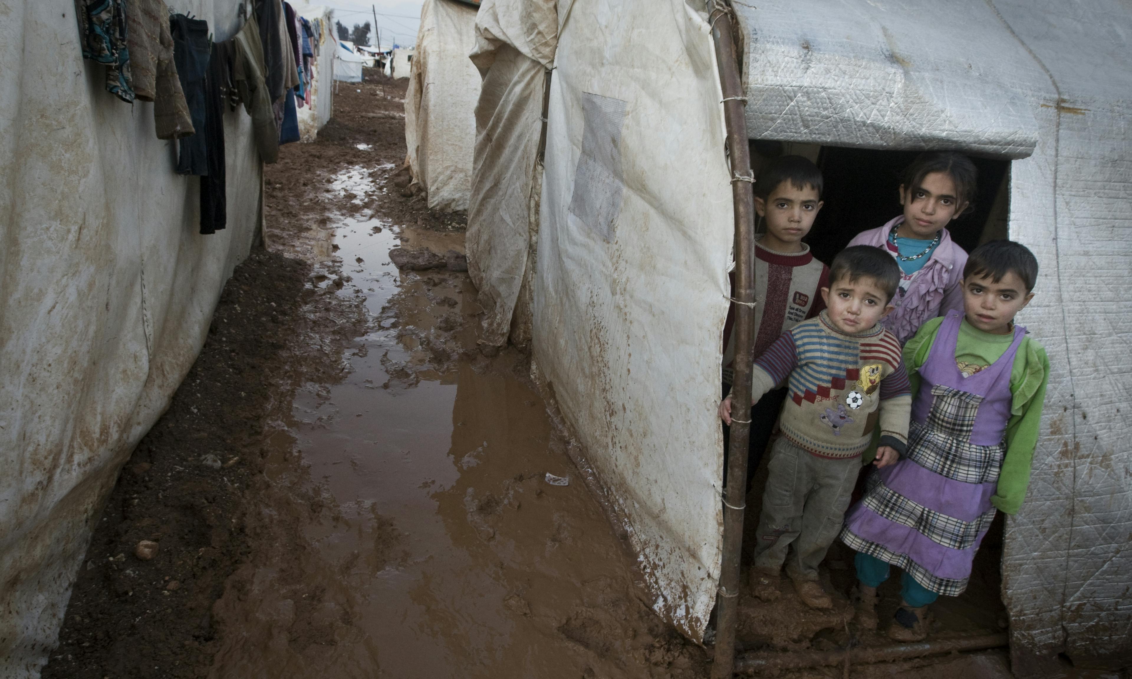 Children stand in the entryway of their tent shelter, in the Bab Al Salame camp for internally displaced persons in Syria