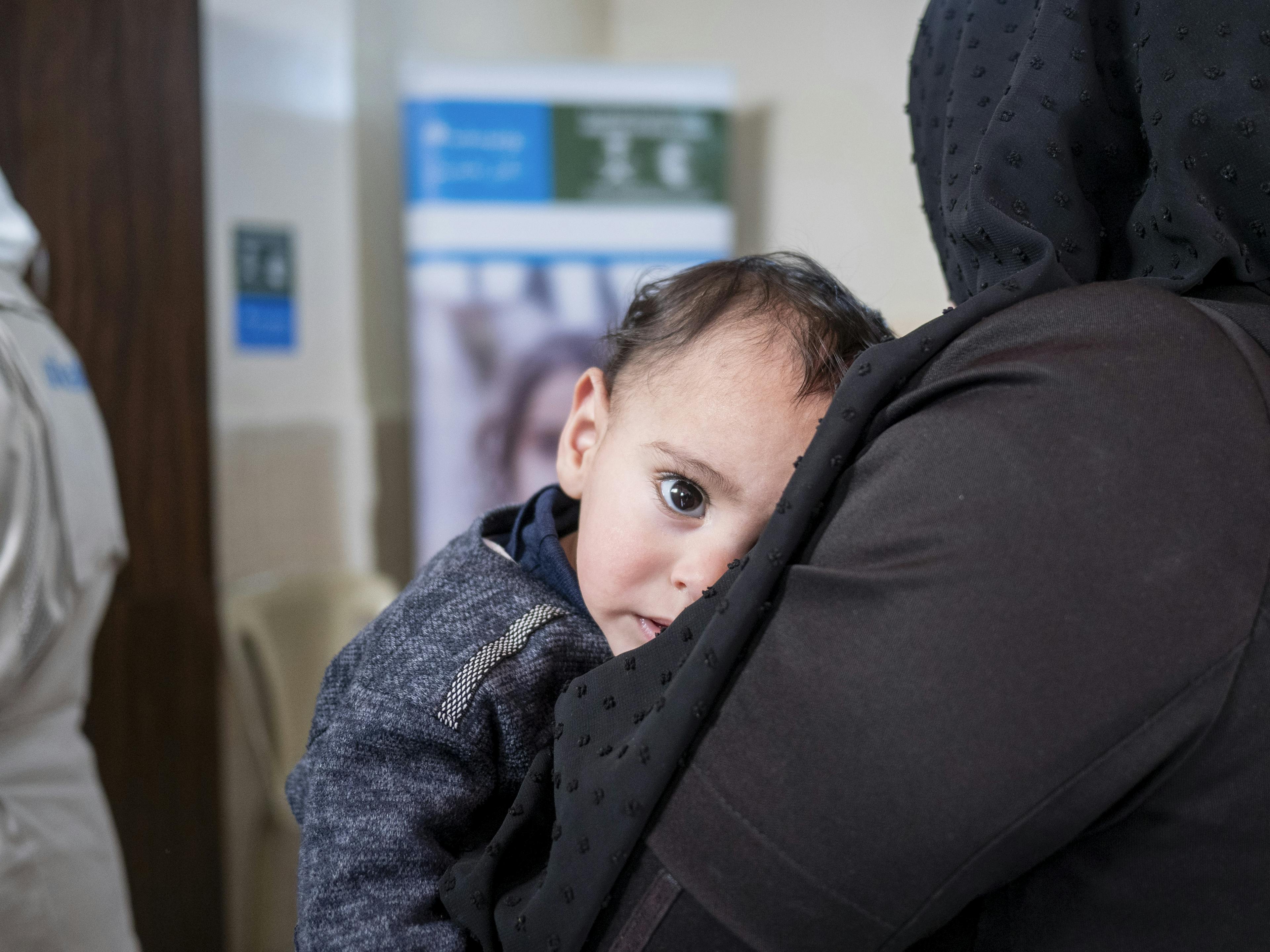 Nemr, 11 months, is held by his mother while waiting for his turn to be examined at a UNICEF-supported health and nutrition centre in Hama city, Syria. Nemr was diagnosed with acute malnutrition during his first visit.