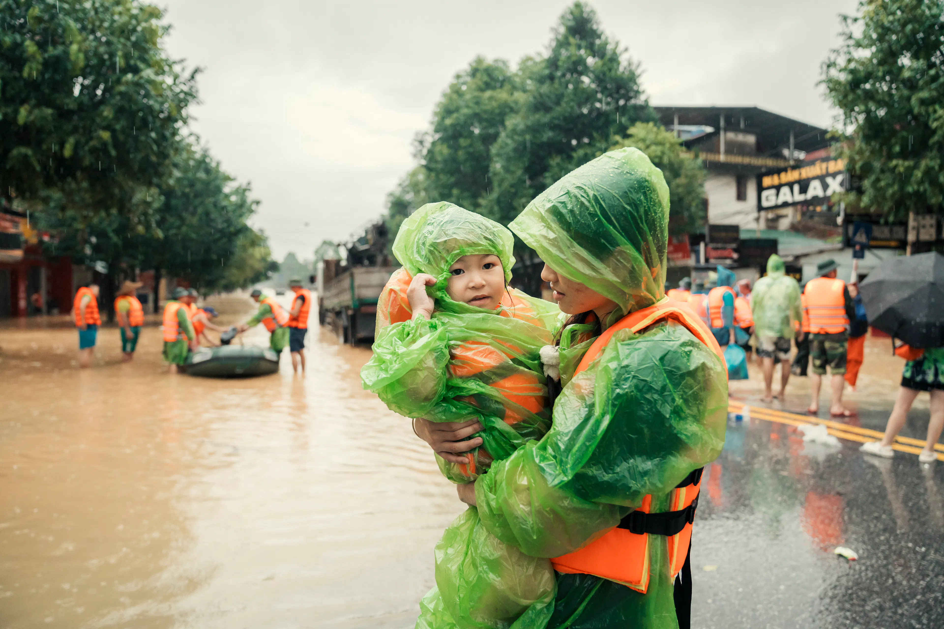 Anh Nguyet, carries her younger sister, Vu Ha Anh, as they evacuate from the severe flood caused by Super Typhoon Yagi in Thai Nguyen City.