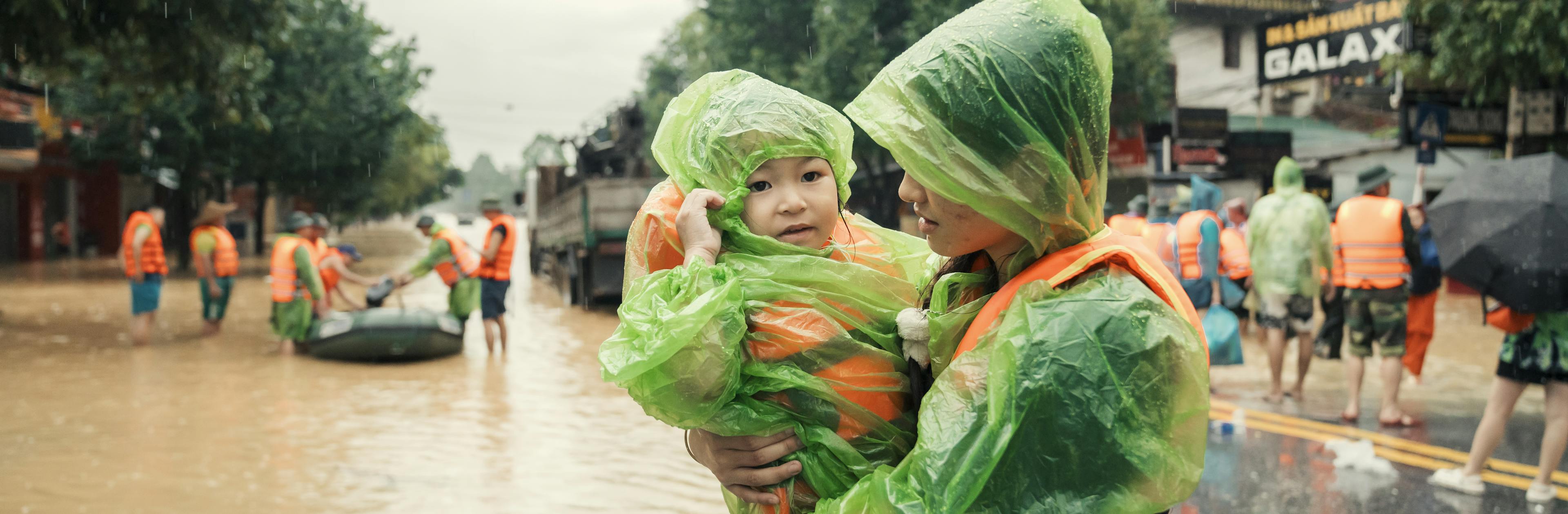 Anh Nguyet, carries her younger sister, Vu Ha Anh, as they evacuate from the severe flood caused by Super Typhoon Yagi in Thai Nguyen City.