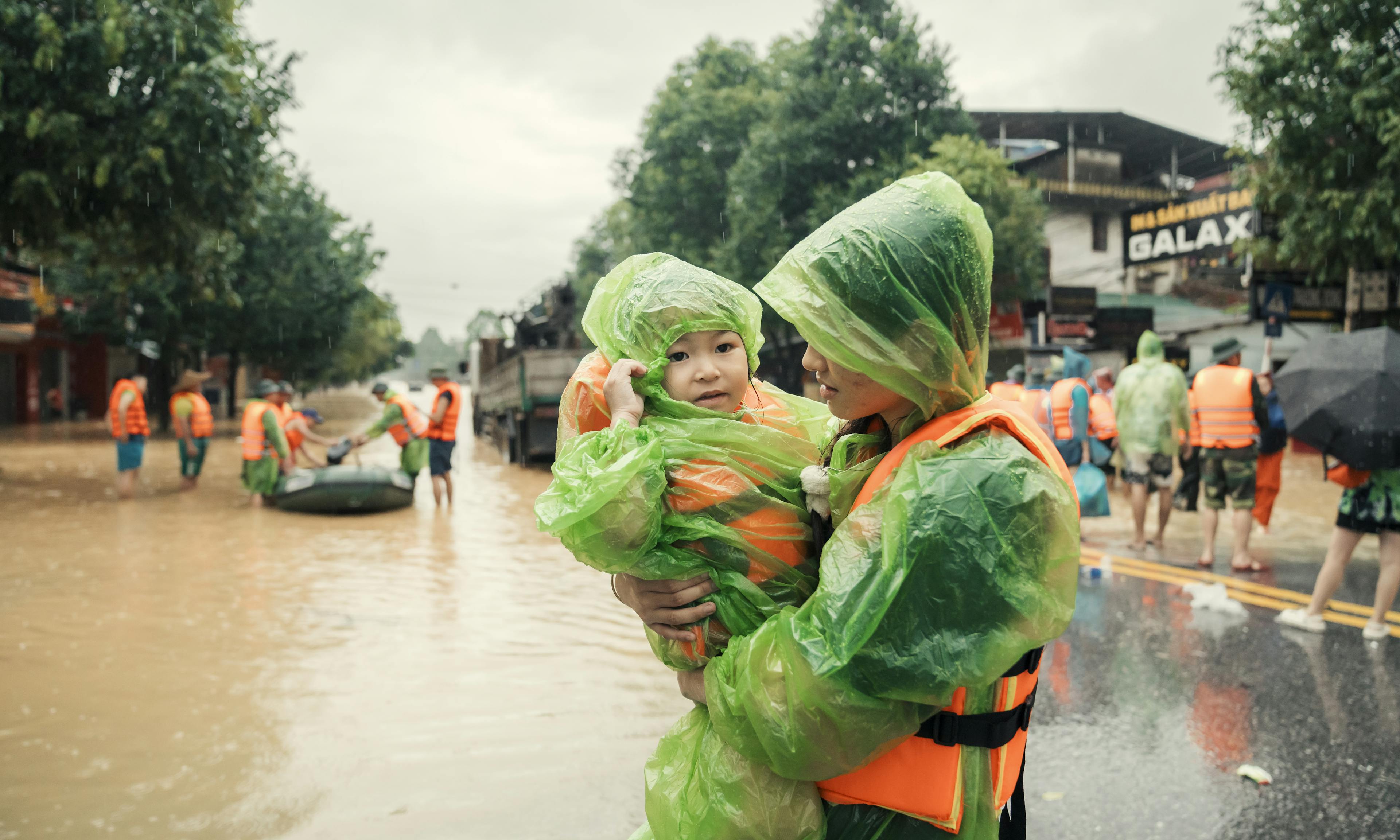 Anh Nguyet, carries her younger sister, Vu Ha Anh, as they evacuate from the severe flood caused by Super Typhoon Yagi in Thai Nguyen City.