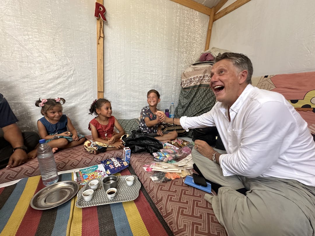 12-year-old Omar shakes hands with UNICEF Spokesperson James Elder in his family tent in Khan Younis, Southern Gaza Strip.