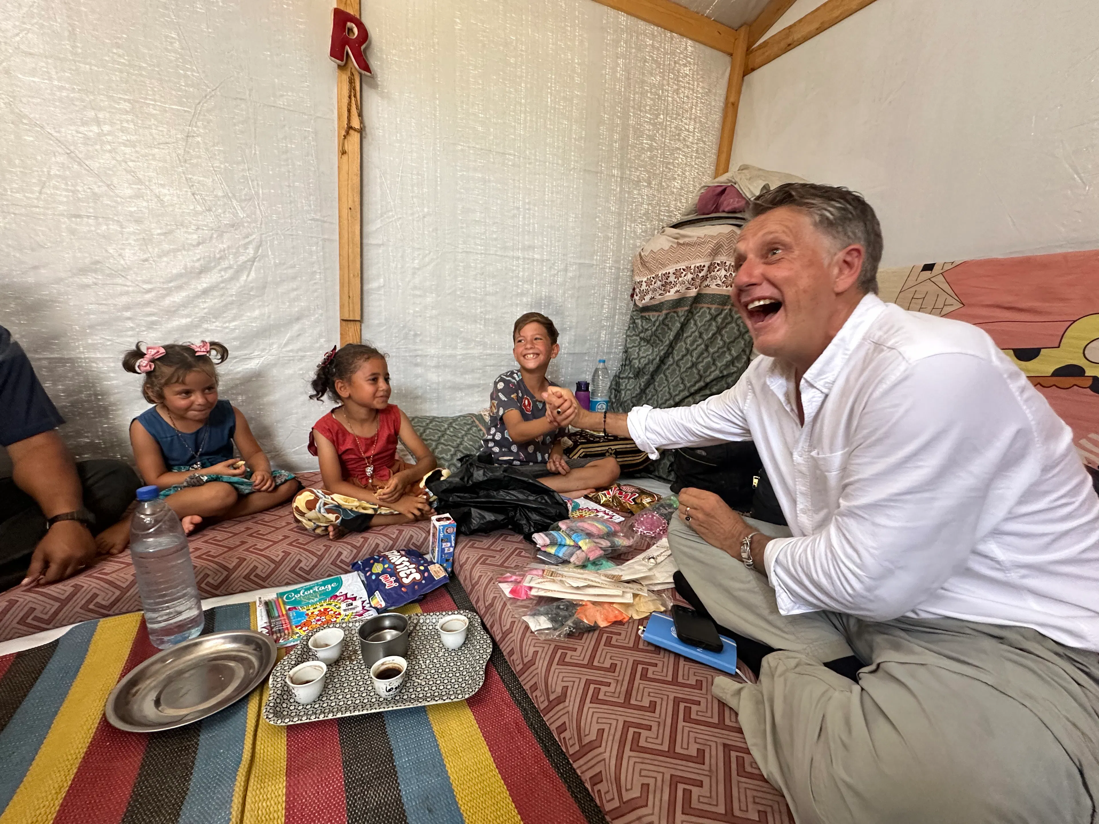 12-year-old Omar shakes hands with UNICEF Spokesperson James Elder in his family tent in Khan Younis, Southern Gaza Strip.