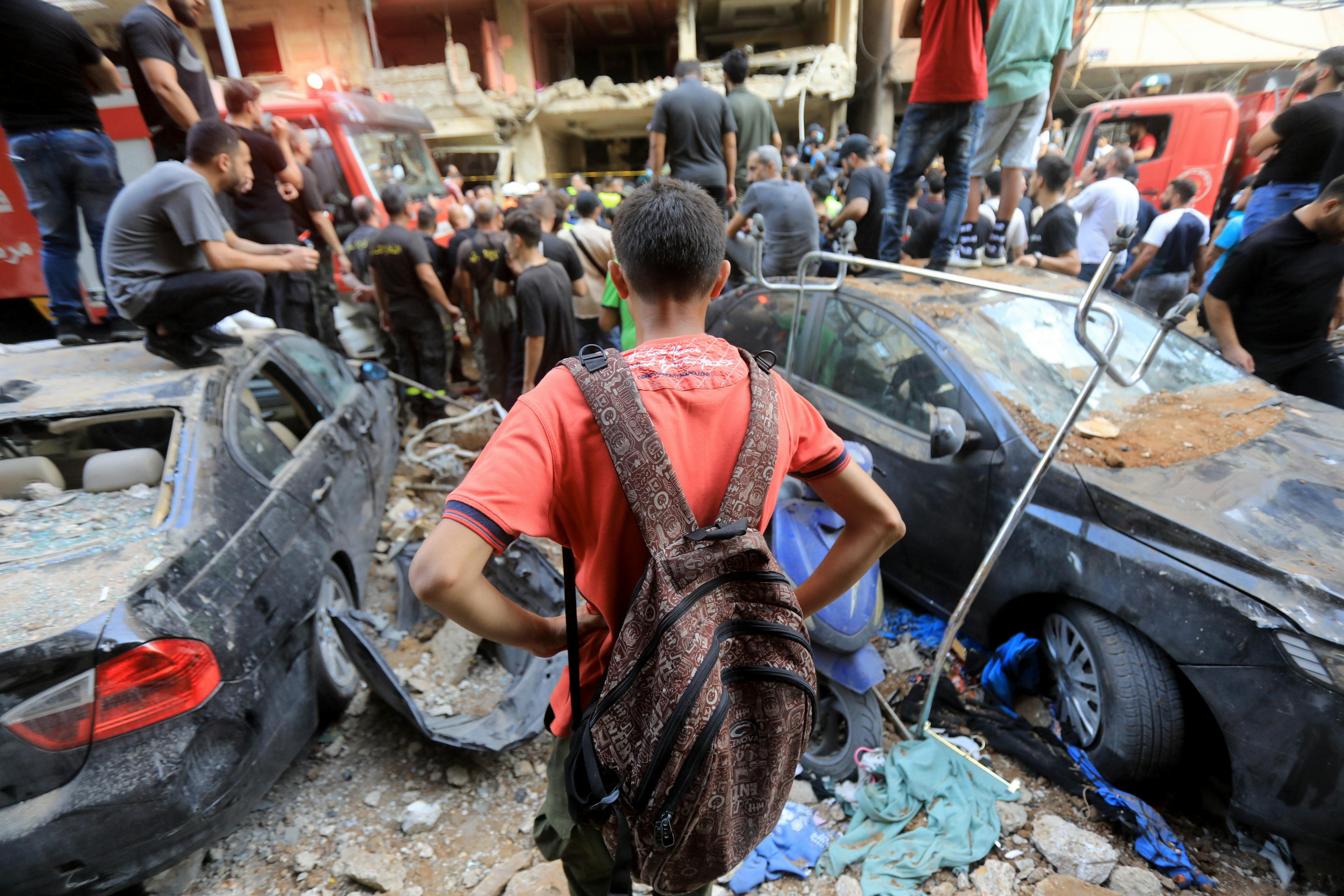 Child watching people trying to remove rubbles from a destructed site in Beirut southern suburbs

