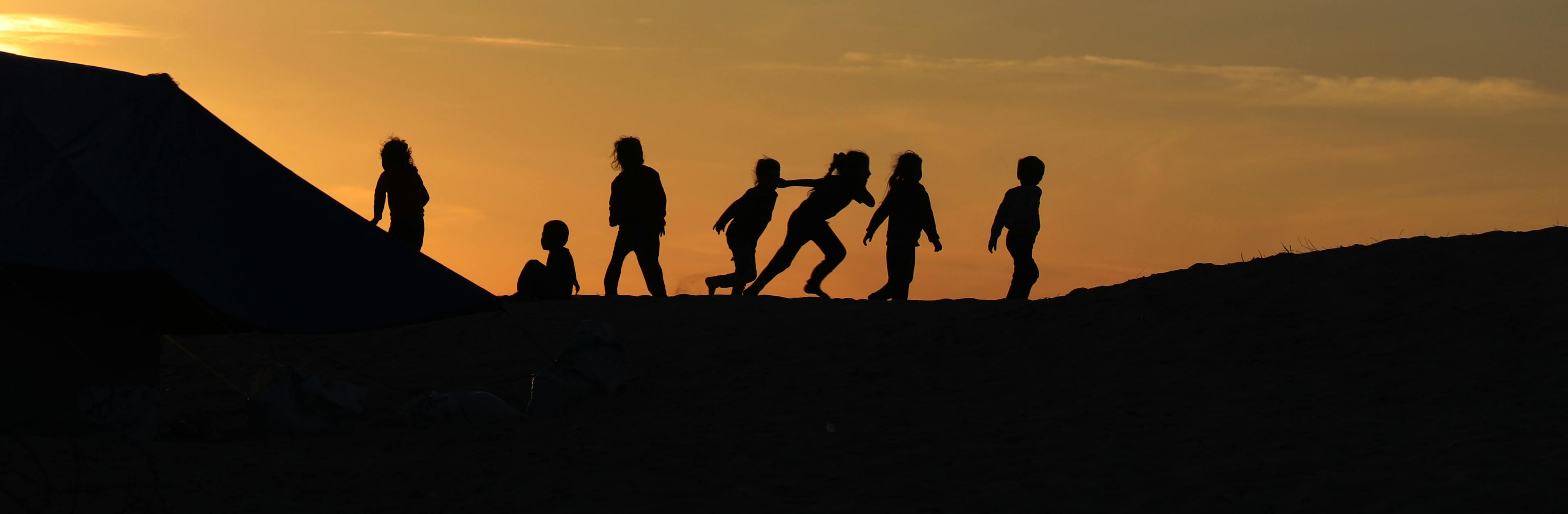 During the sunset, children are playing together in Rafah, southern the Gaza Strip