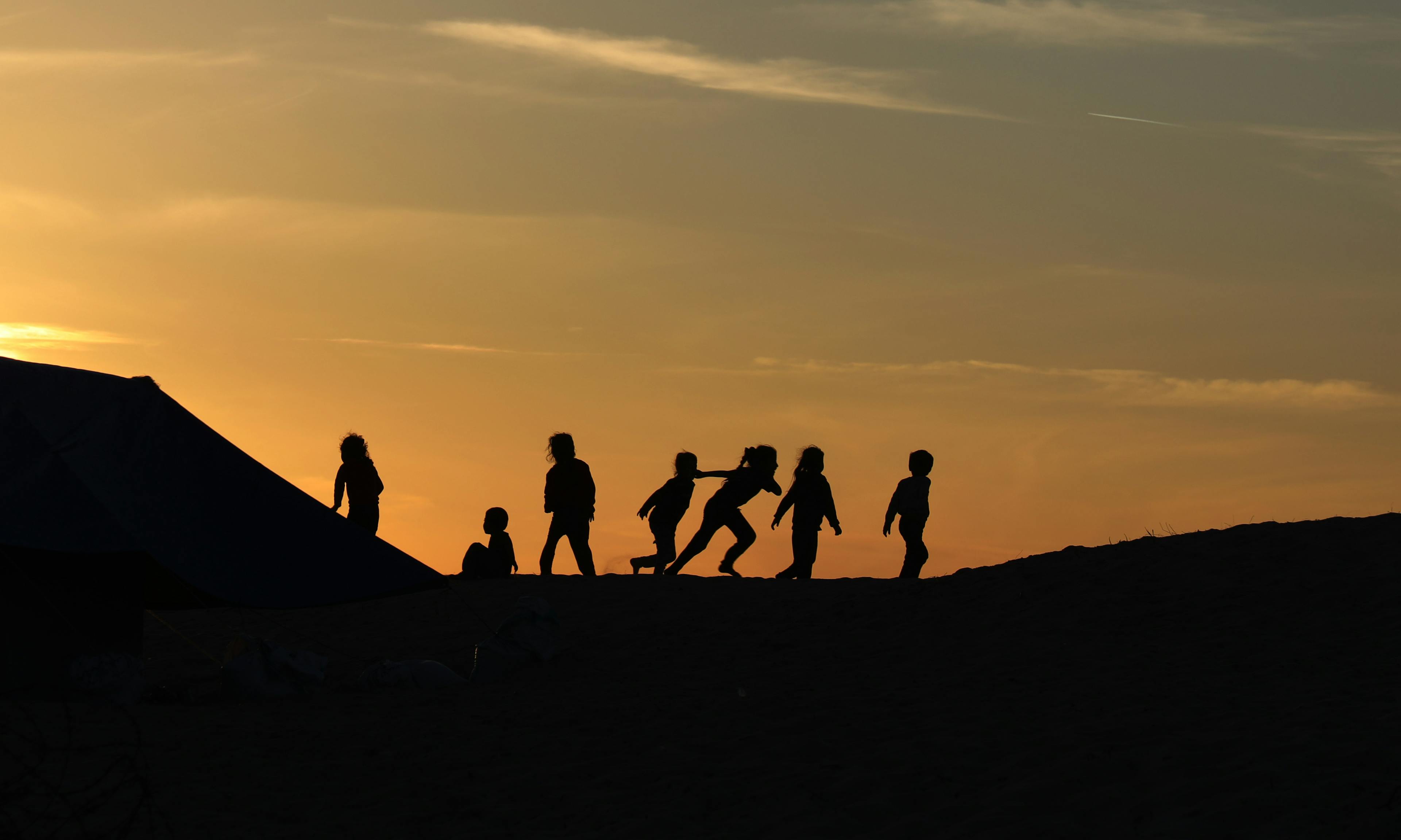 During the sunset, children are playing together in Rafah, southern the Gaza Strip