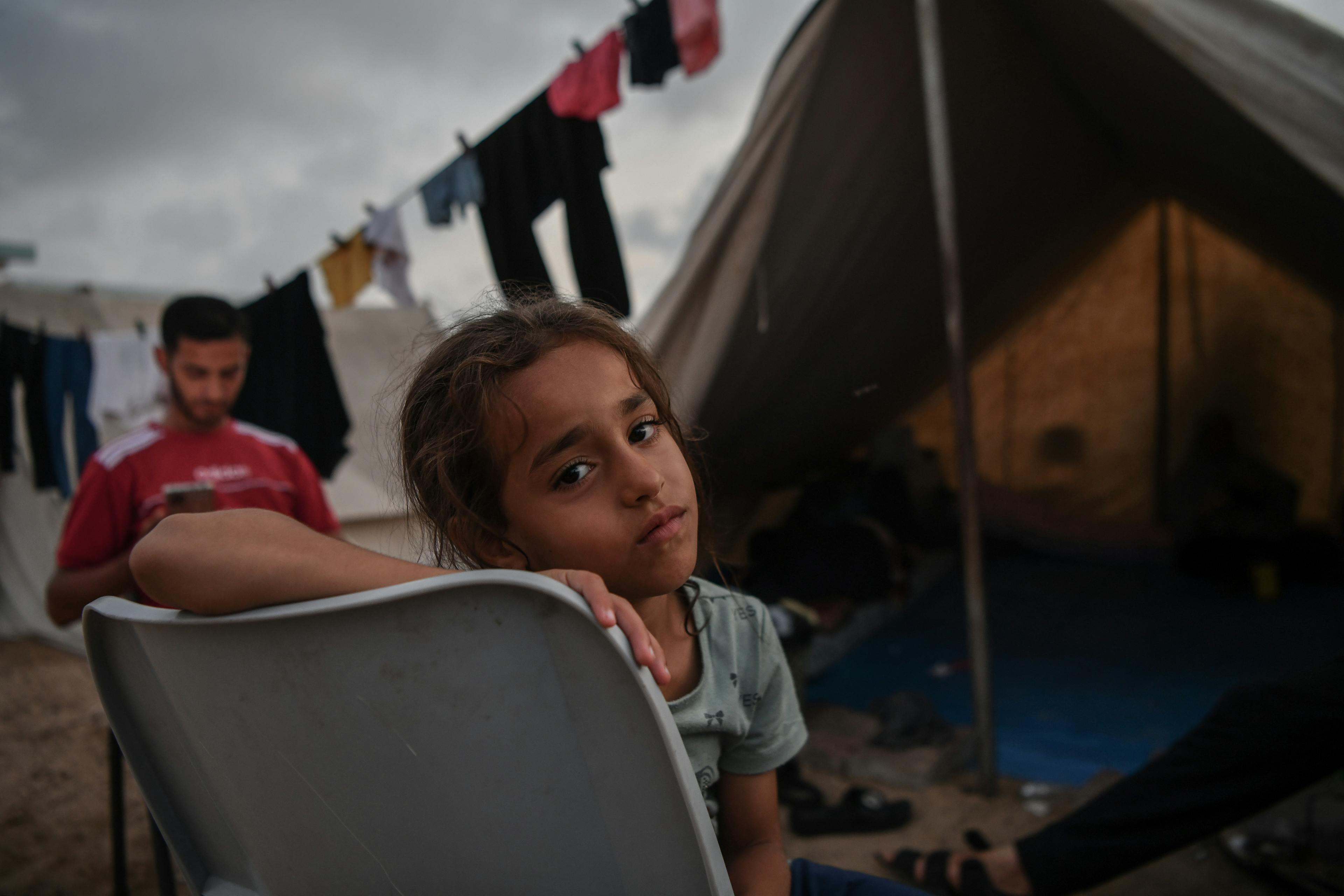 November 2023, a girl sits in front of her tent at UNRWA shelter camp in Khan Younis, southern the Gaza Strip.