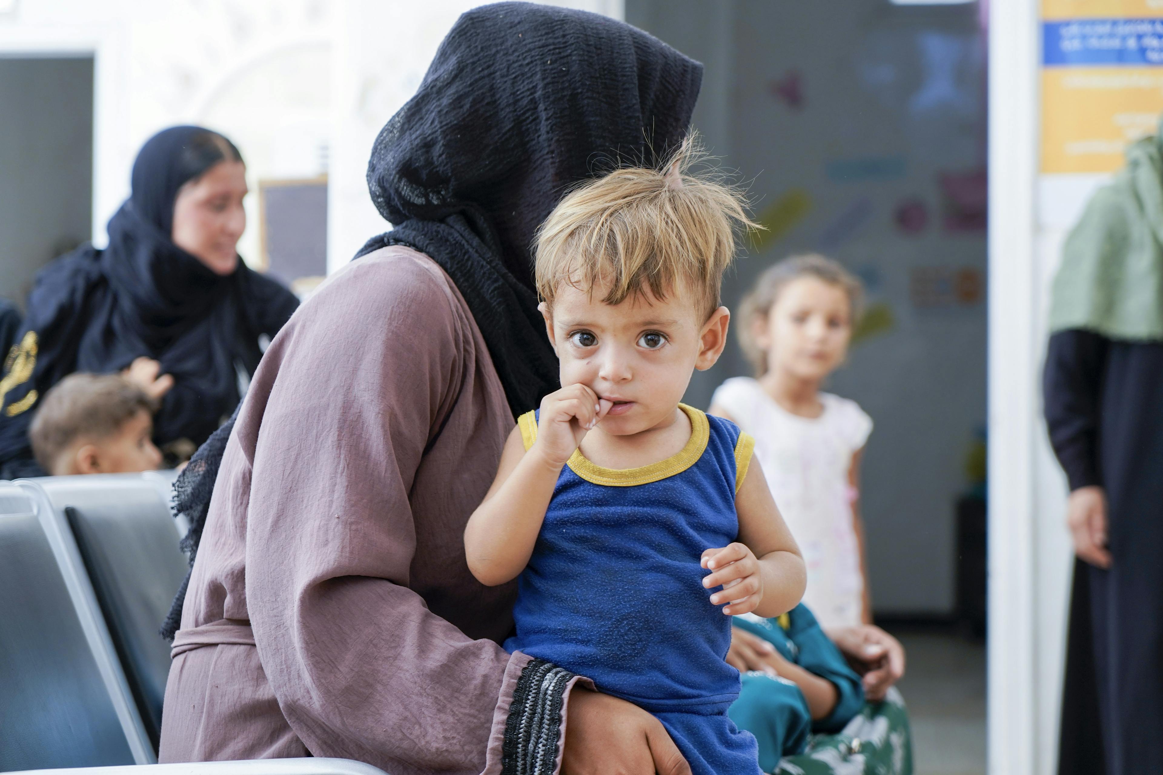 Nayla, 36, with her son Saif, 1.8, waiting at a UNICEF- supported clinic in Al-Hasakeh city, Syria, 18 August 2024. 

