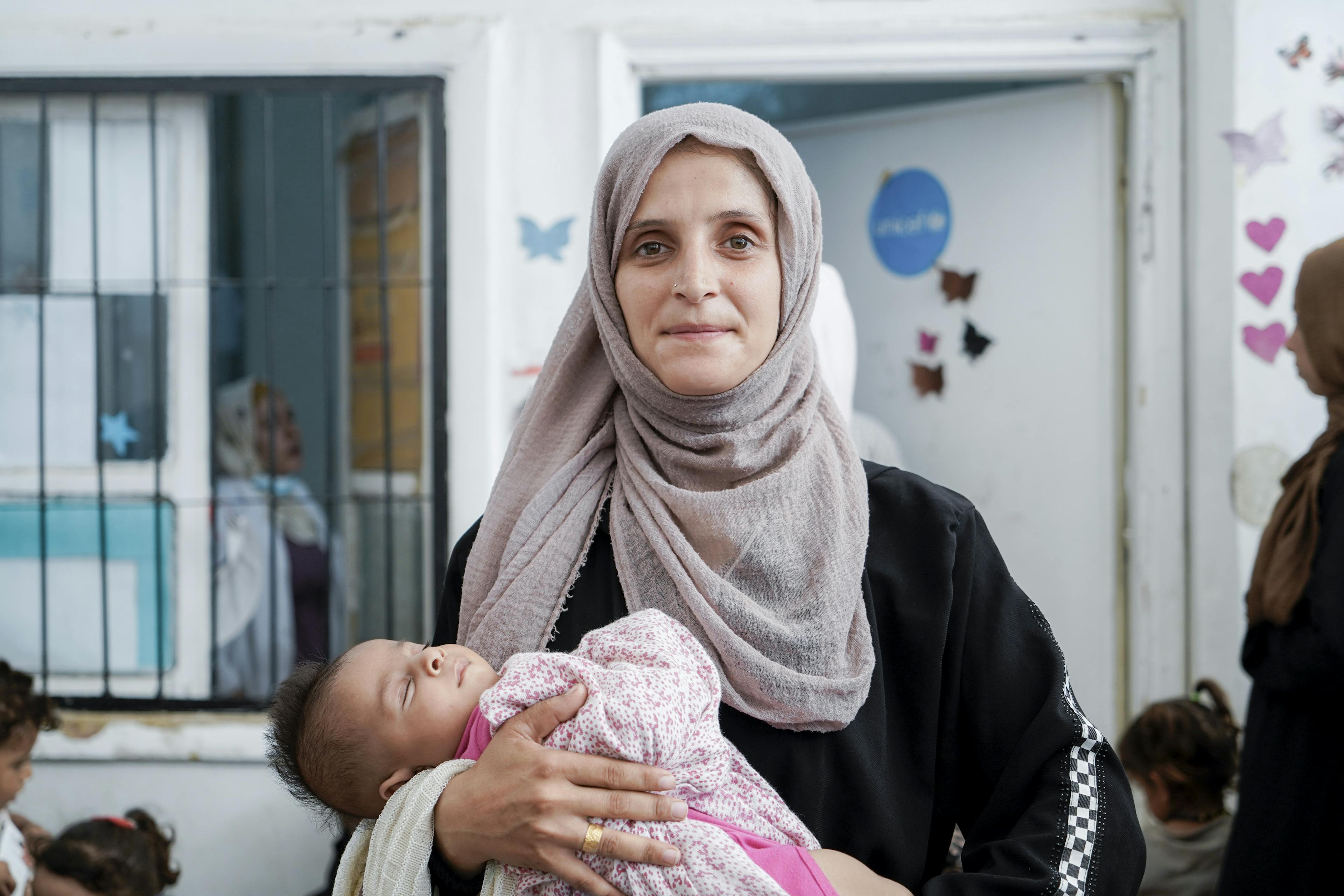 Najah, 30, with her daughter waits for her turn at a UNICEF- supported clinic in Al- Hassakeh city, Syria