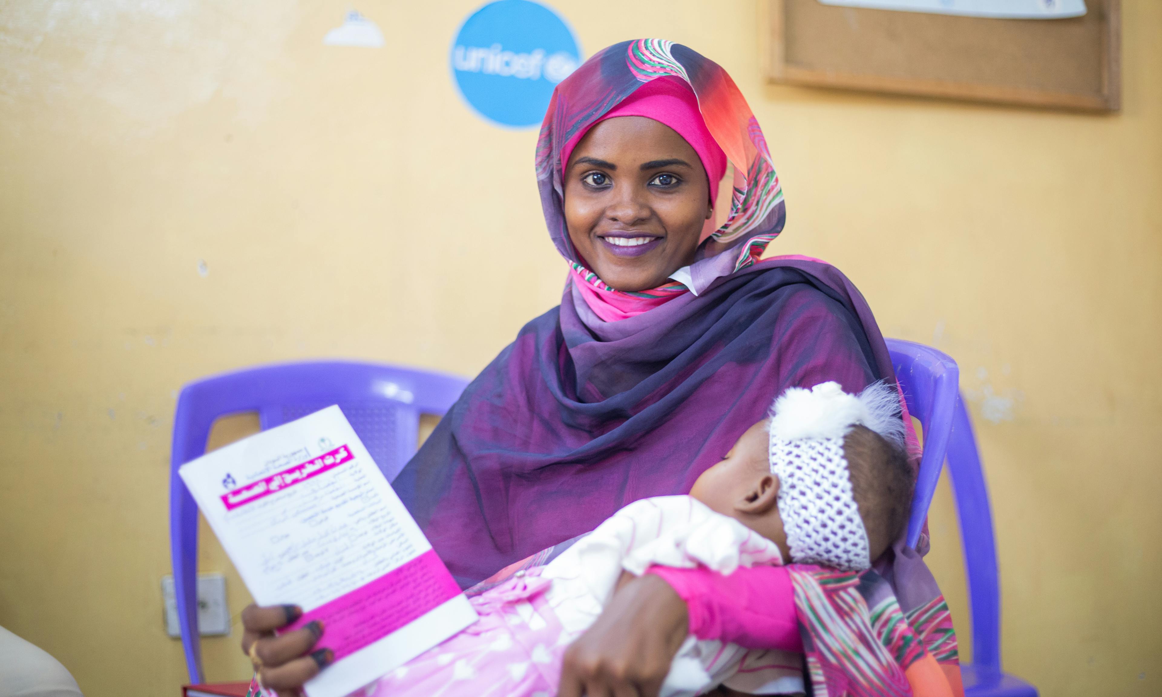 On 4 November 2024 in Gedaref, Sudan, 6-month-old Adan Mohammed is held by her mother, Romisa Mohammad Ali. Adan is the very first child to receive the malaria vaccine in Sudan.