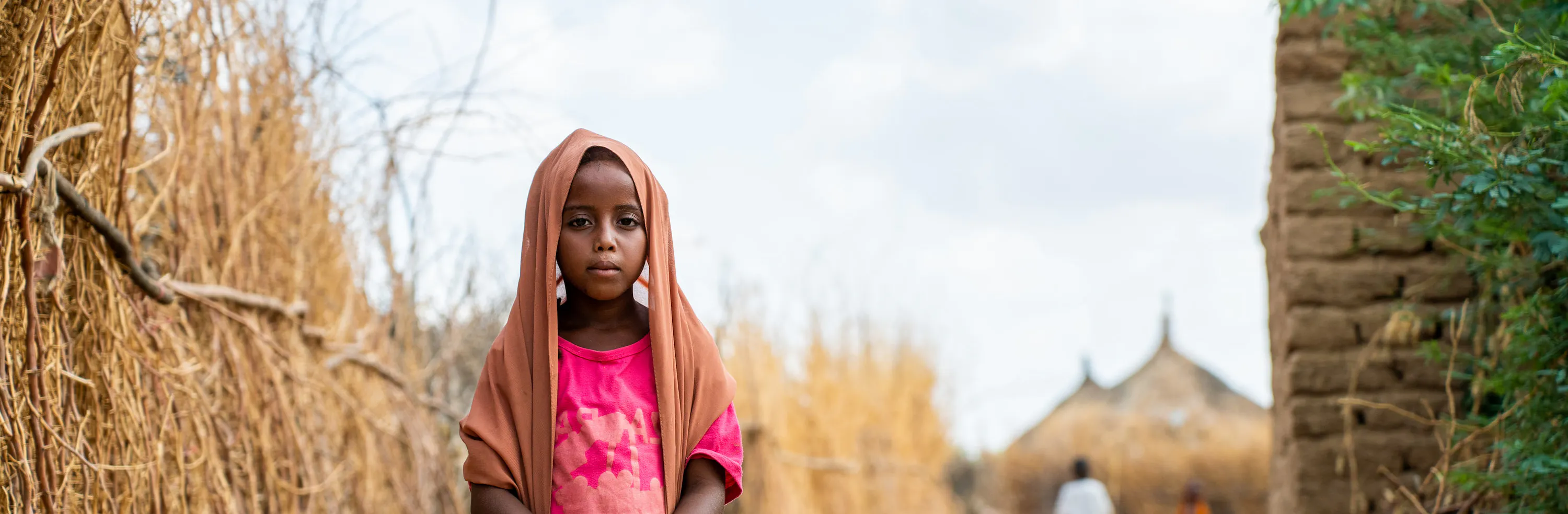 7-year-old Muzn stands in a path in Wadsharefey refugee camp in Kassala state, Sudan.