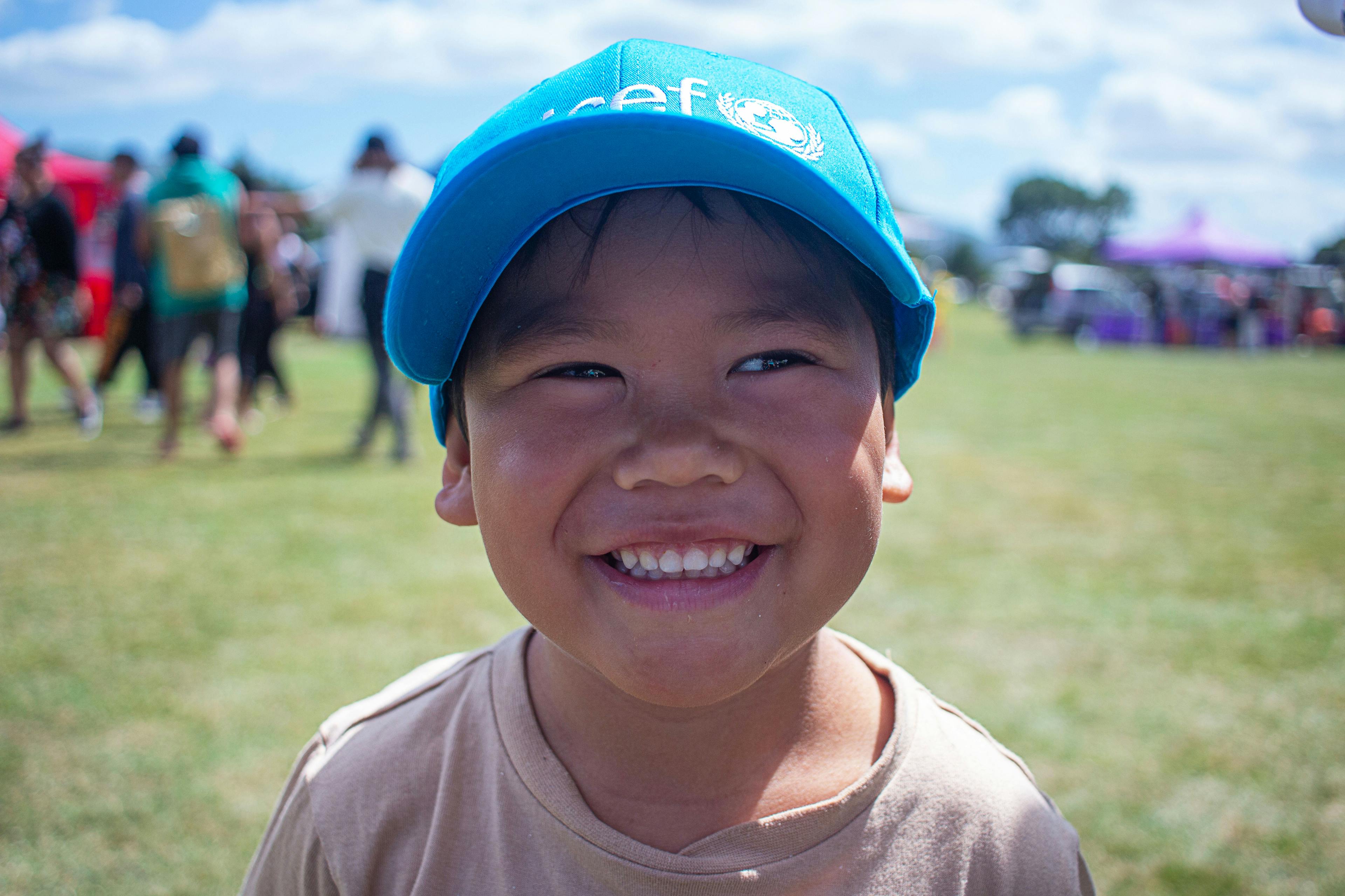 A young boy smiles at UNICEF children's day