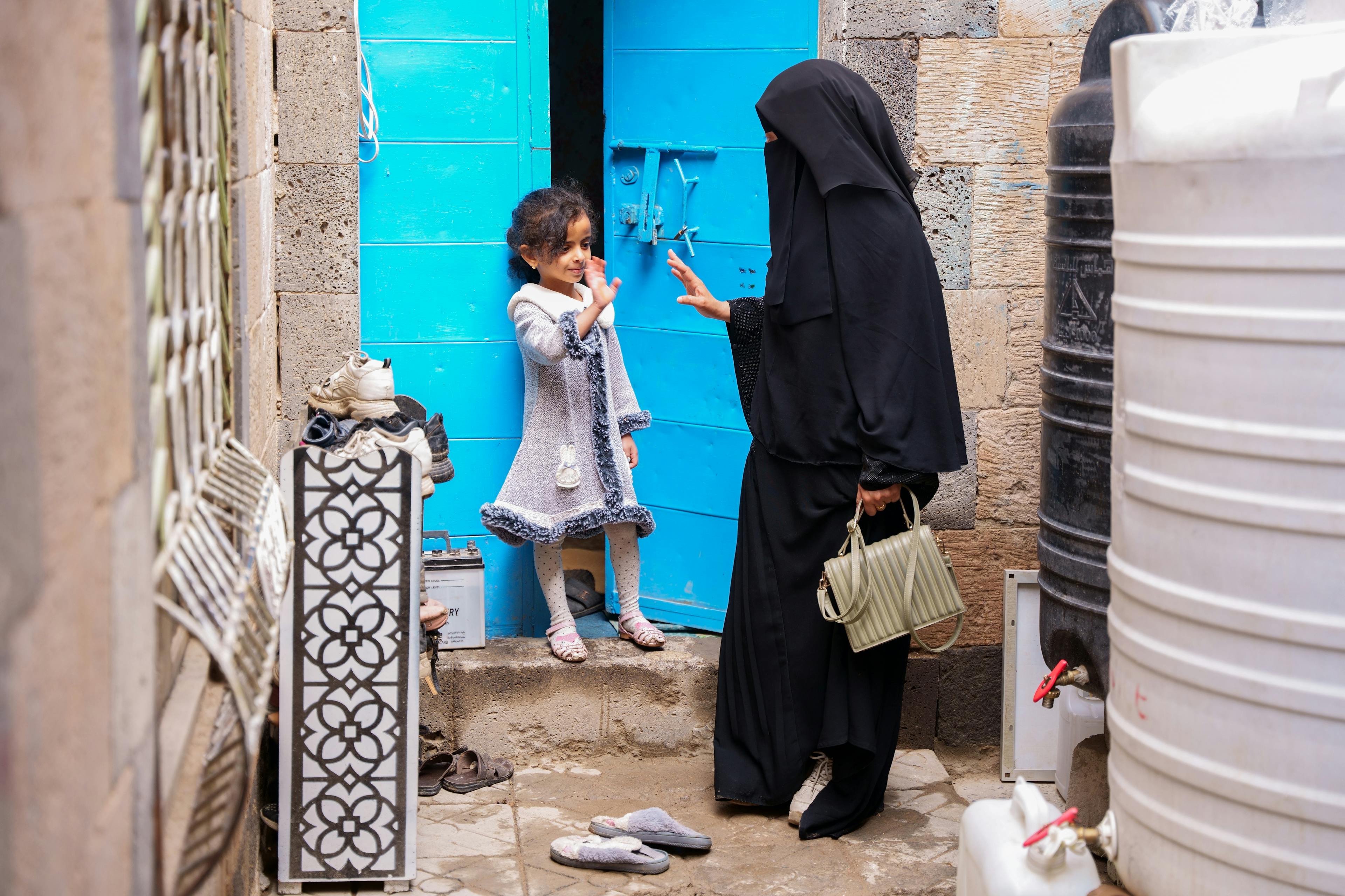 Suroor Al-Shama’a, a 33-year-old midwife, waves goodbye to her daughter before heading to work in Dhamar Governorate, Yemen.