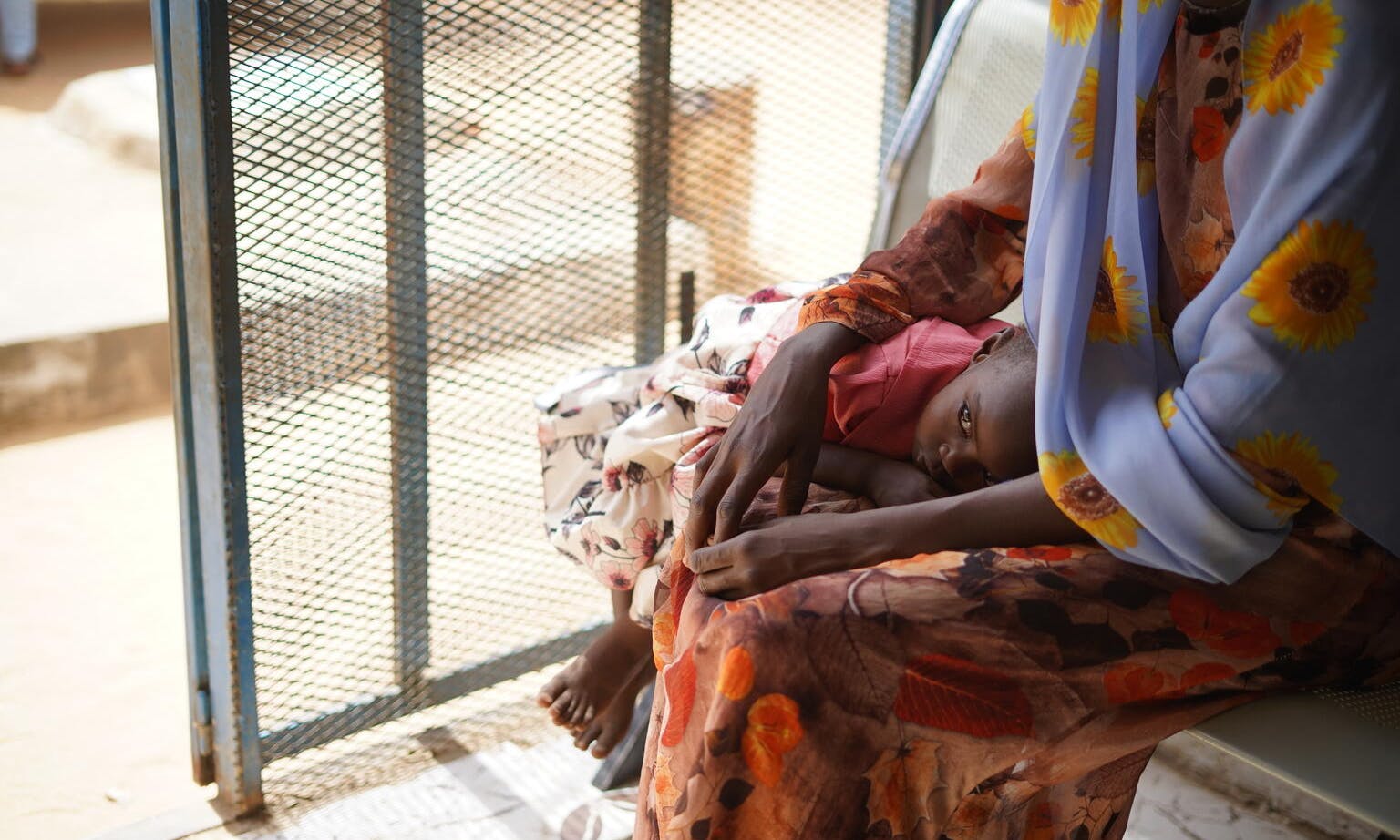 May 2023, a parent awaits healthcare services at Fashir Reproductive health centre in Sudan. The centre received WASH and health supplies from UNICEF