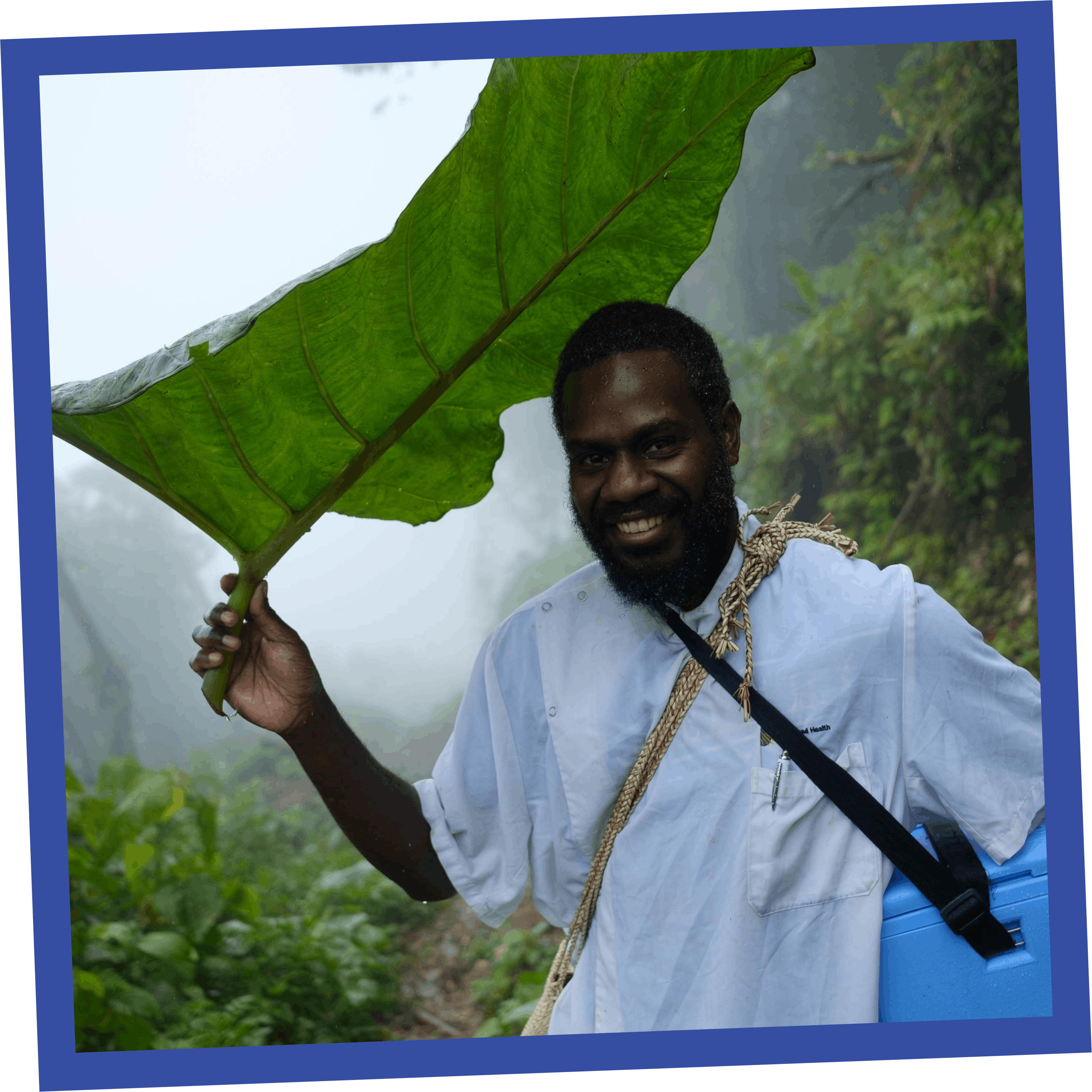Health & Medicine- Far up a hillside in the distance General Nurse Dominic, from Melsisi Mini Hospital, trekking accross the mountainous Pentecost Island to deliver the vaccine order to the remote Tsingbwege Dispensary.