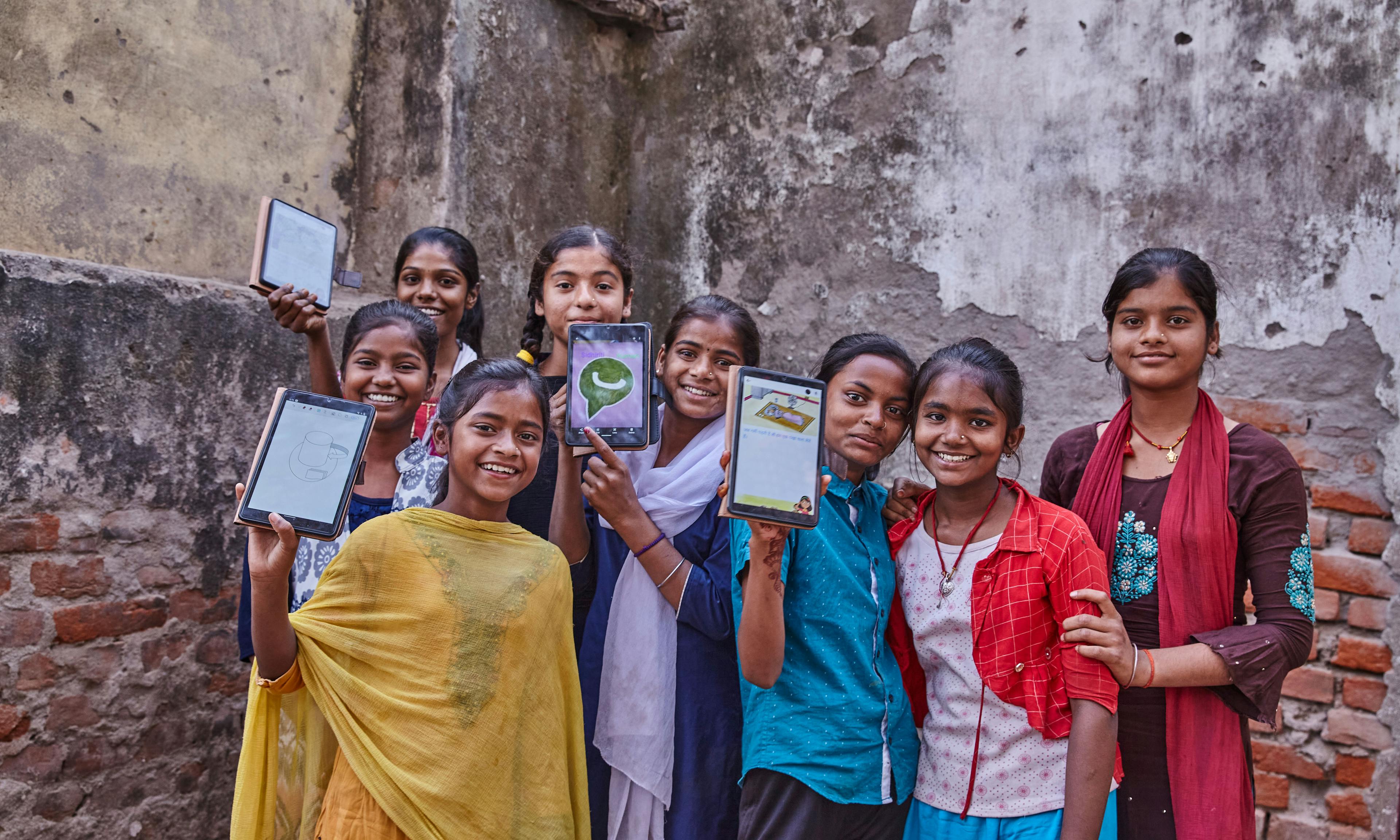 A group of girls in India holding tablets donated by UNICEF