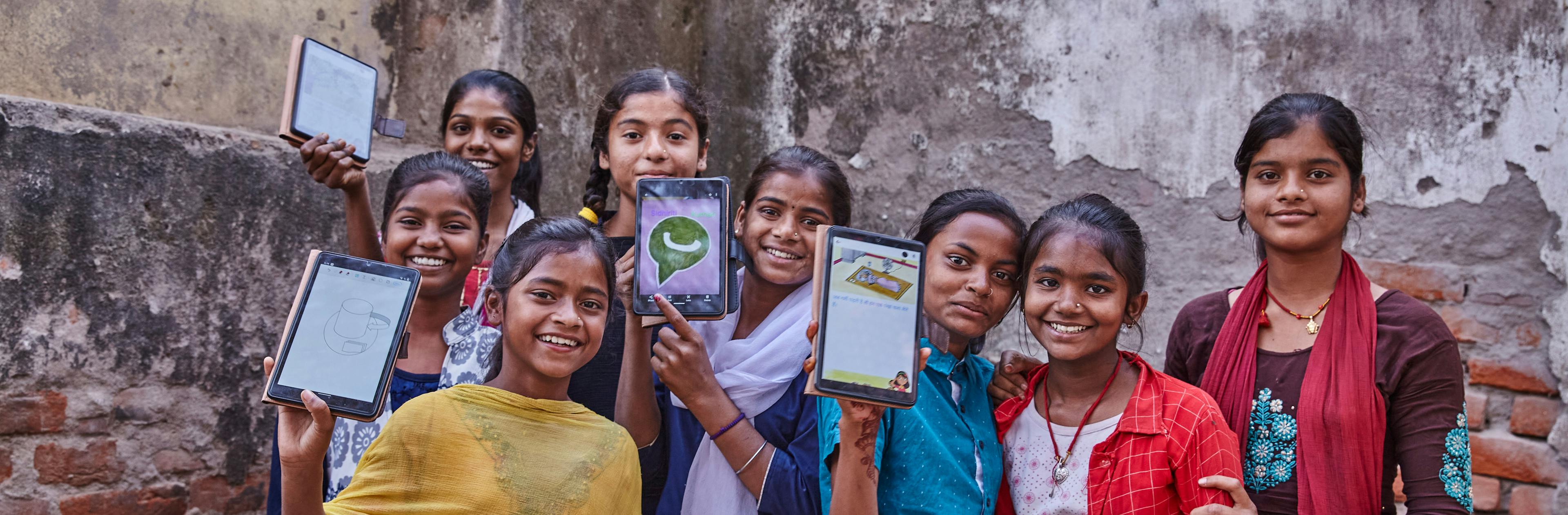 A group of girls in India holding tablets donated by UNICEF