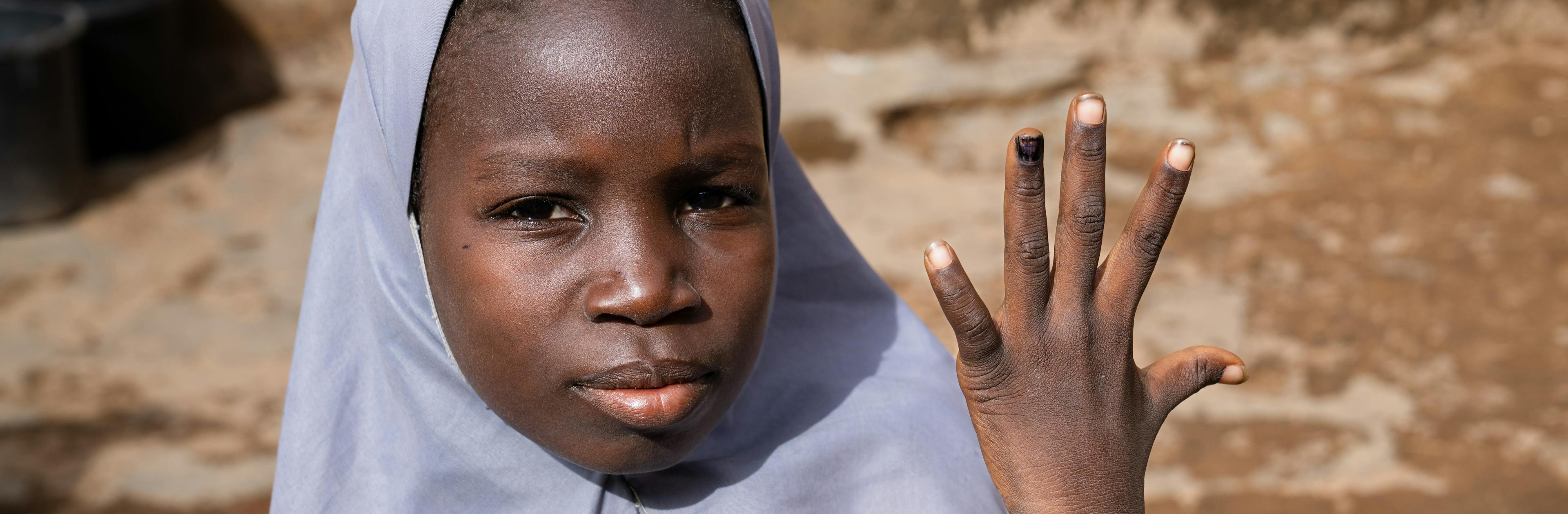 Fatima Mansir, 12, shows her nail marked with ink to show that she has been vaccinated against the human papillomavirus (HPV) at her home in Katsina, Nigeria, on 30 May 2024.
