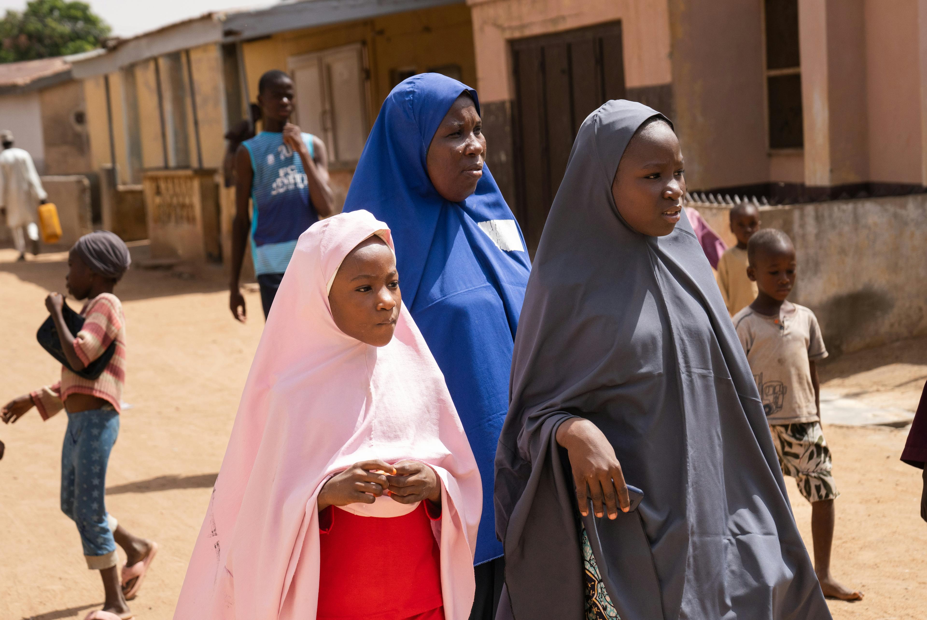Volunteer Community Mobilizer (VCM), Binta Salisu, 42, middle , walks with Zainab Abubakar, 9, left, and her sister Fatima Abubakar, 12, right, enroute to a mobile human papillomavirus (HPV) clinic in Katsina, Nigeria on 31 May 2024