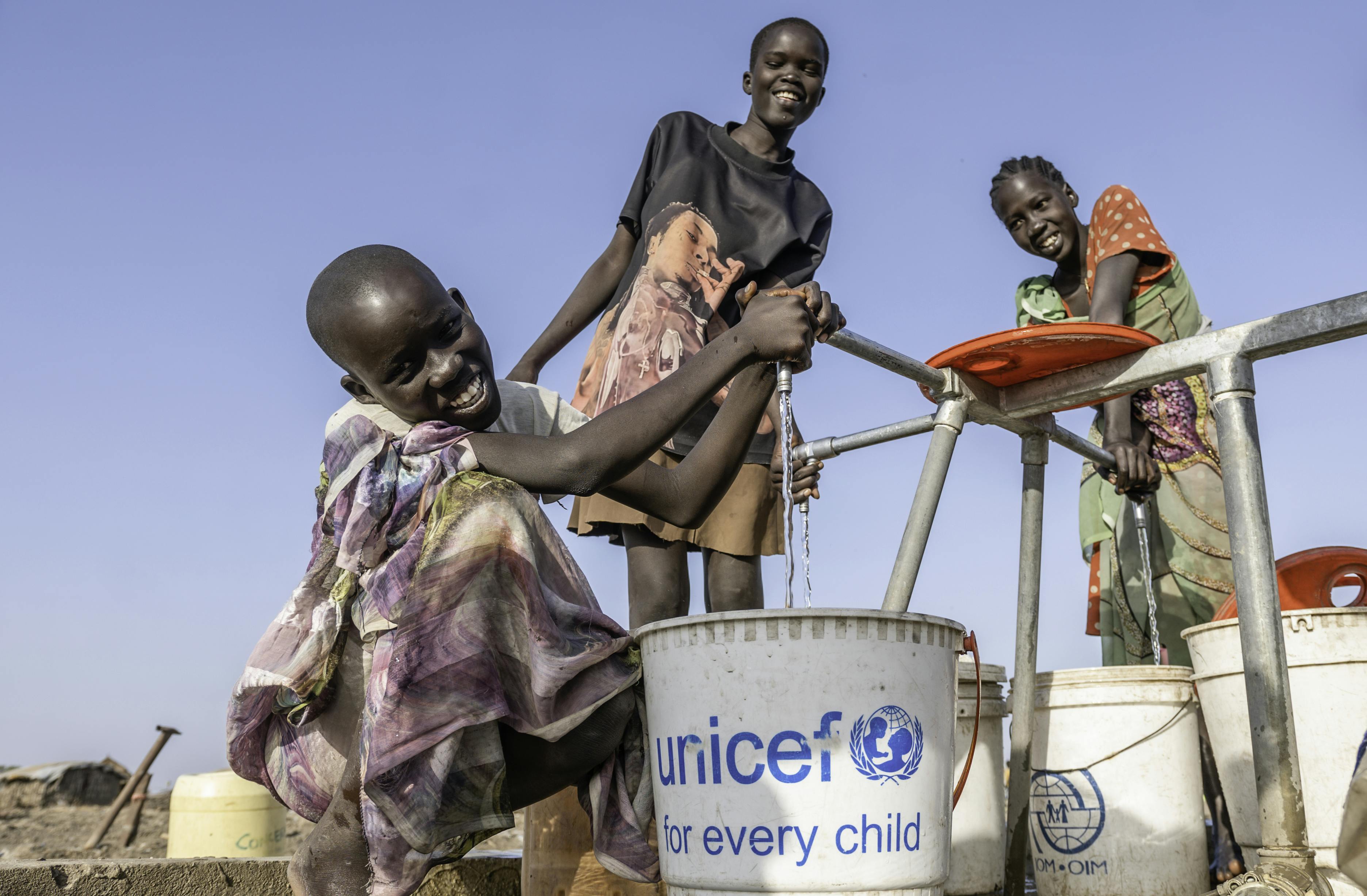 Young girls collecting water at the new community water point in Delmet, Rubkona, Bentiu State. This water point was set up by The water, taken from floodwaters, is cleaned with aluminum sulfate.