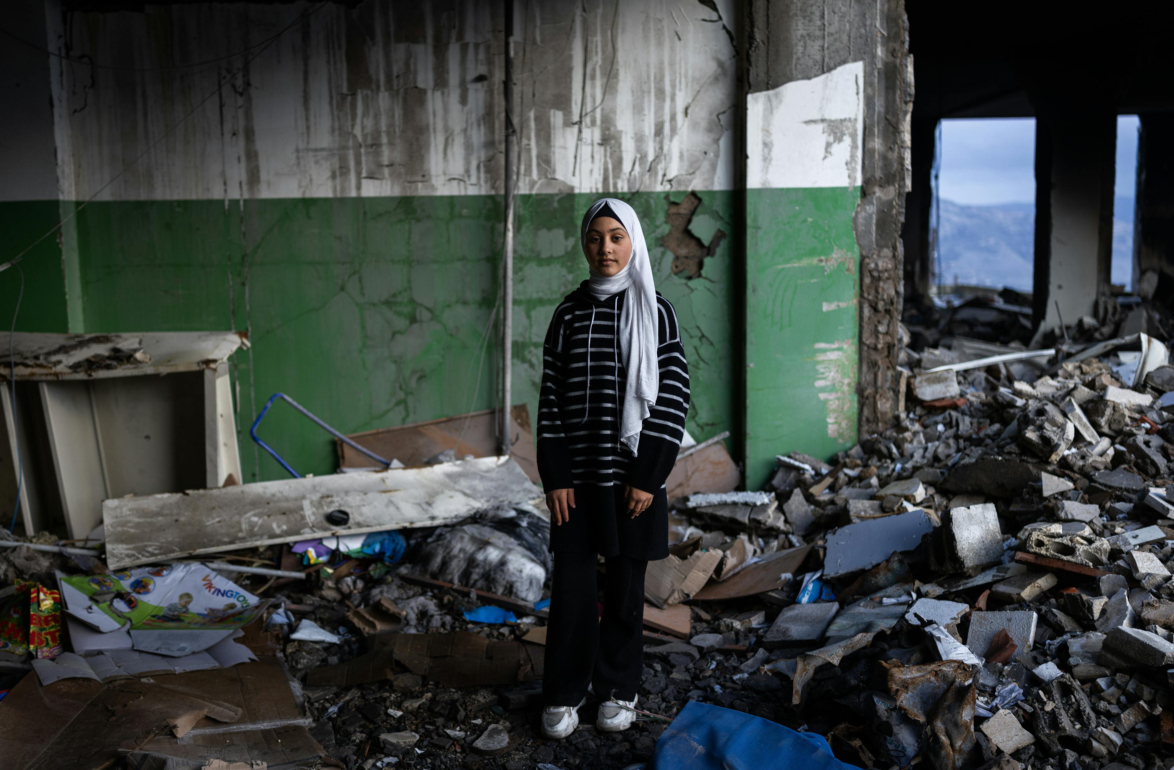 Khiam, Lebanon – February 13, 2025: Khouloud, 10, a girl, poses for a portrait inside her destroyed school. It's been around 2 weeks she is  back to classes. When I came back and saw everything in ruins, I felt overwhelmed. I had no words when I got home that day. But despite everything, we have to keep going and continue our education.”