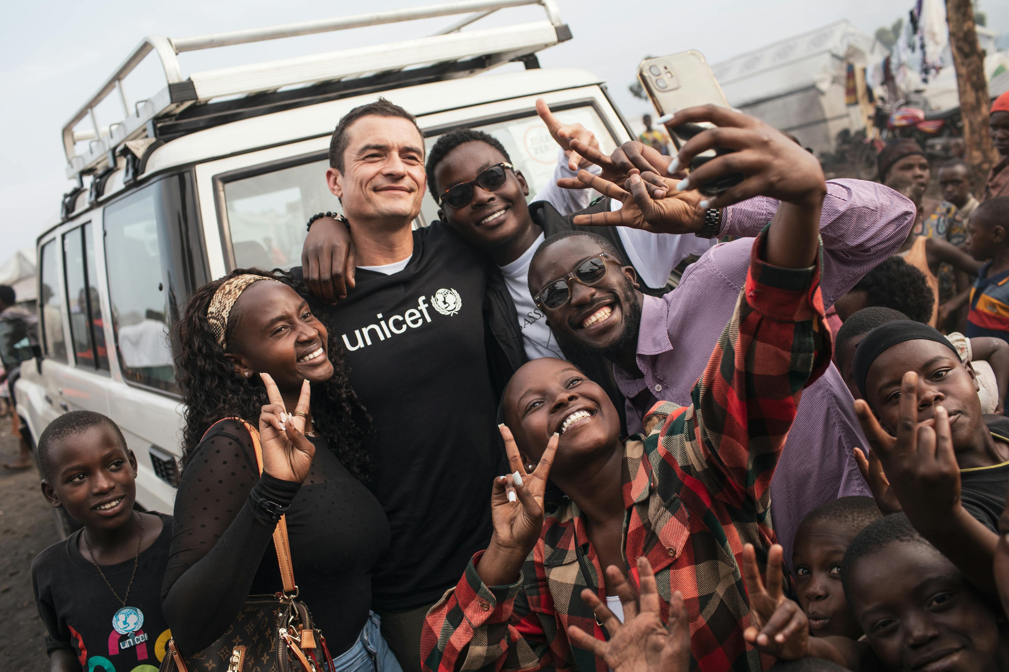 On 1 June 2024, UNICEF Goodwill Ambassador Orlando Bloom poses for a selfie with child reporters and members of children’s committees, with whom he’s just met at the child-friendly space in the Bulengo site for internally displaced people in Goma, eastern Democratic Republic of the Congo.