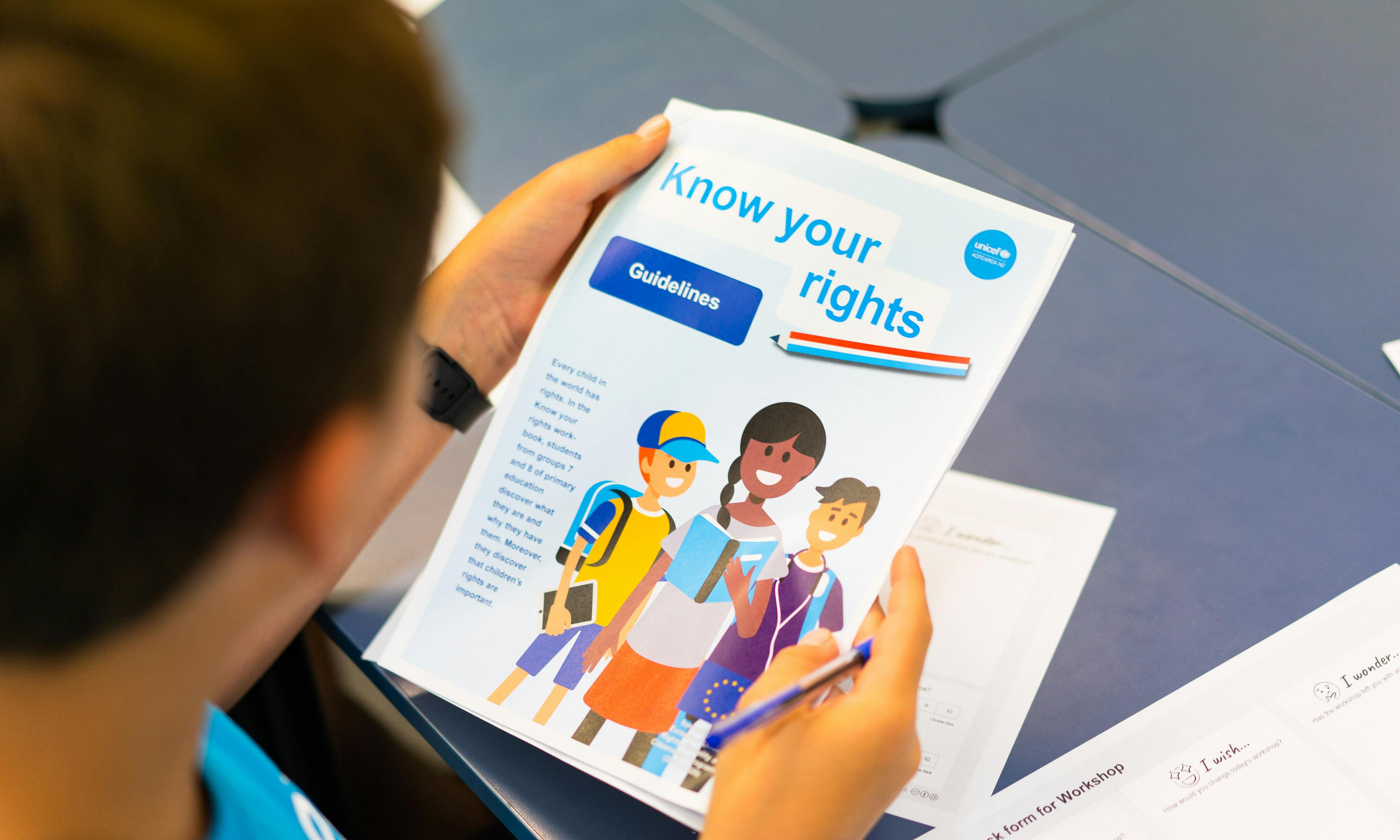 A student in New Zealand reading a document about the UN Charter on the Rights of the Child