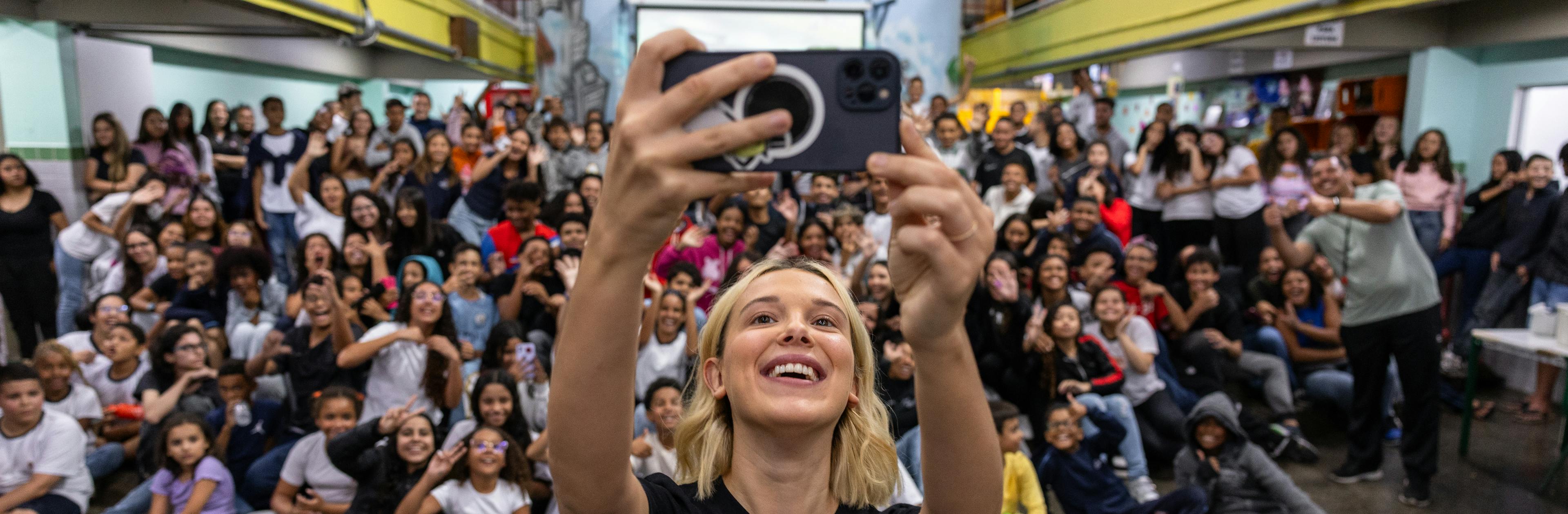 On 17 March 2025 in São Paulo, Brazil, UNICEF Goodwill Ambassador Millie Bobby Brown takes a selfie with the students at Olinda Menezes Serra Vidal Elementary School, which is located in a vulnerable neighbourhood where UNICEF operates.