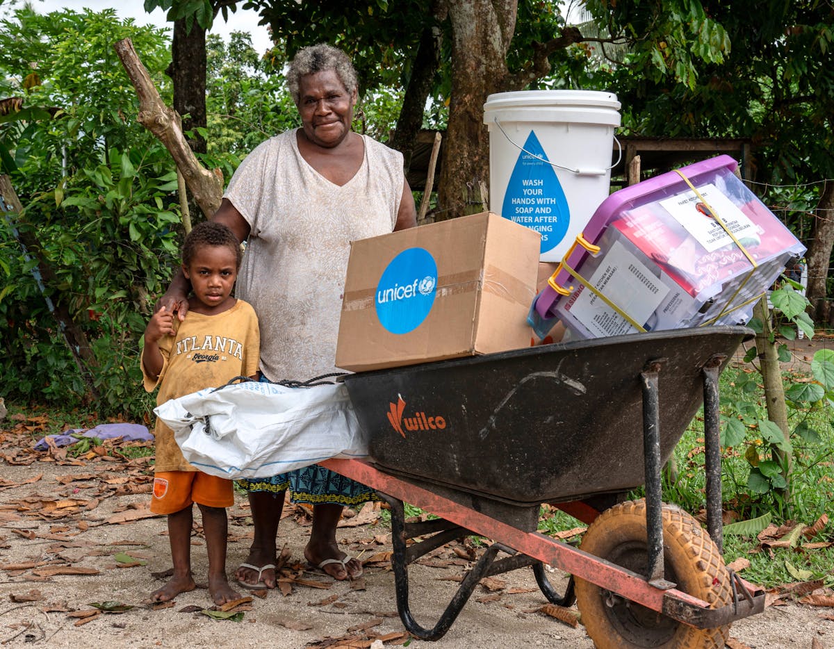 Jacklyn, grandmother and her 4 year old grandson Johnathan with their families emergency kit distributed by UNICEF Vanuatu WASH officer Sandrine alongside partners to families in the Erakor Bridge community after the Earthquake. Erakor, Efate, SHEFA, Vanuatu