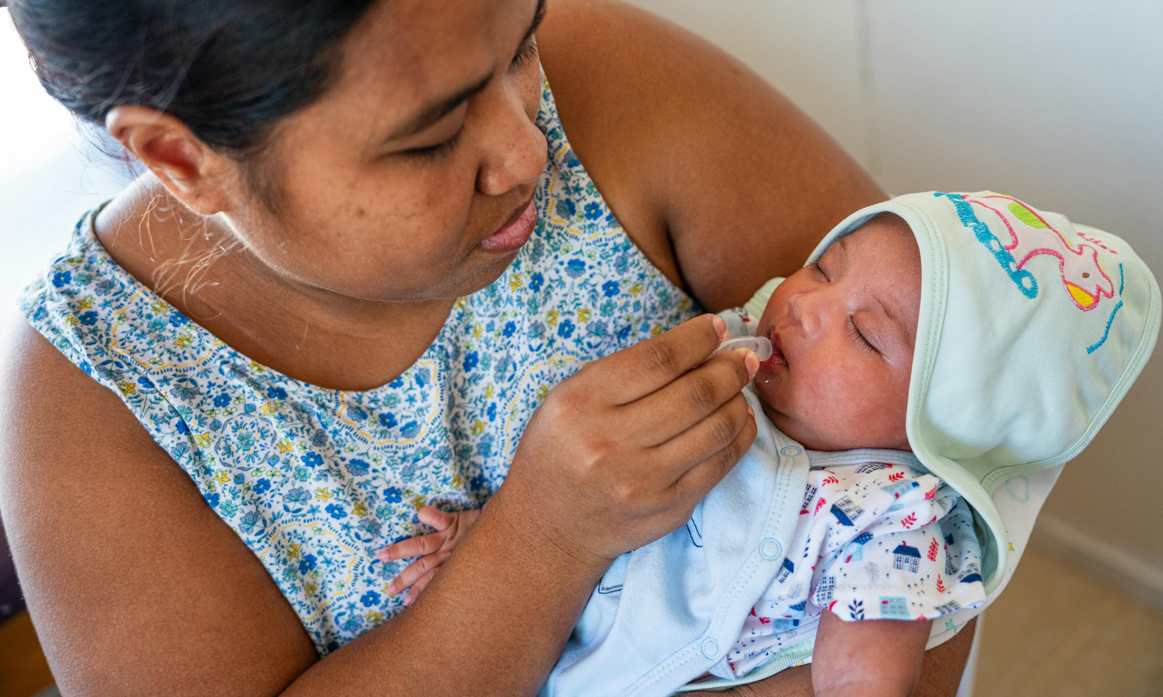 A mother gives a vaccine to her baby at London Clinic in Kiritimati, Kiribati