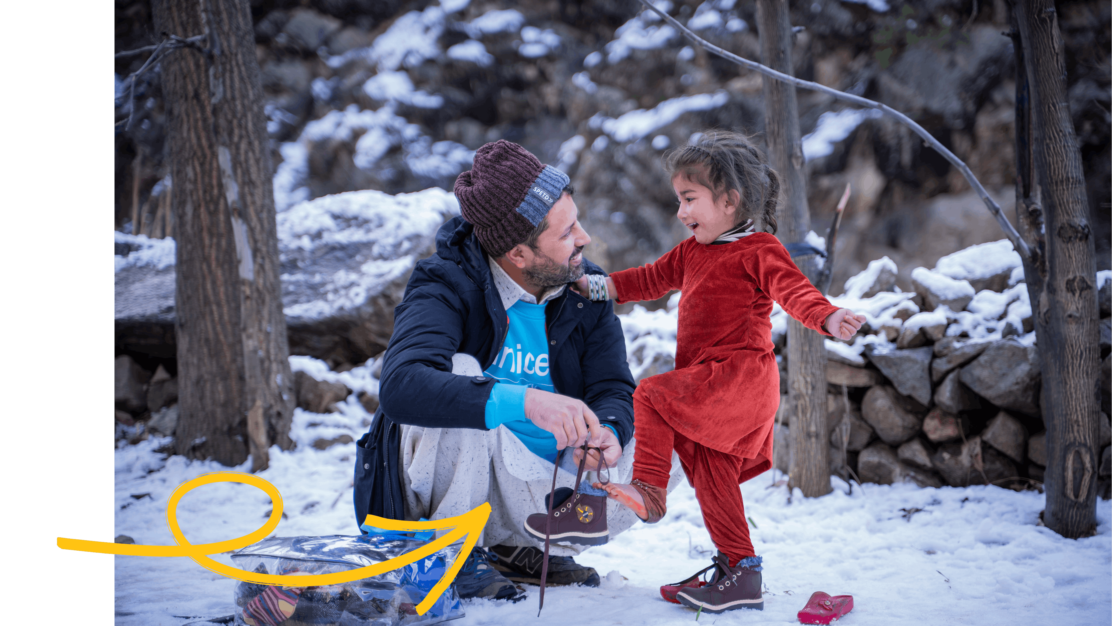 On 1 February 2023 in Pakistan, Zaheer Ahmad, Planning, Monitoring and Evaluation Officer with UNICEF Pakistan, helps 3-year-old Muskan put on new shoes she has just received as part of the winter kit provided to her by UNICEF during a distribution in Sulool Daramdala village, Upper Dir District, Khyber Pakhtunkhwa Province.