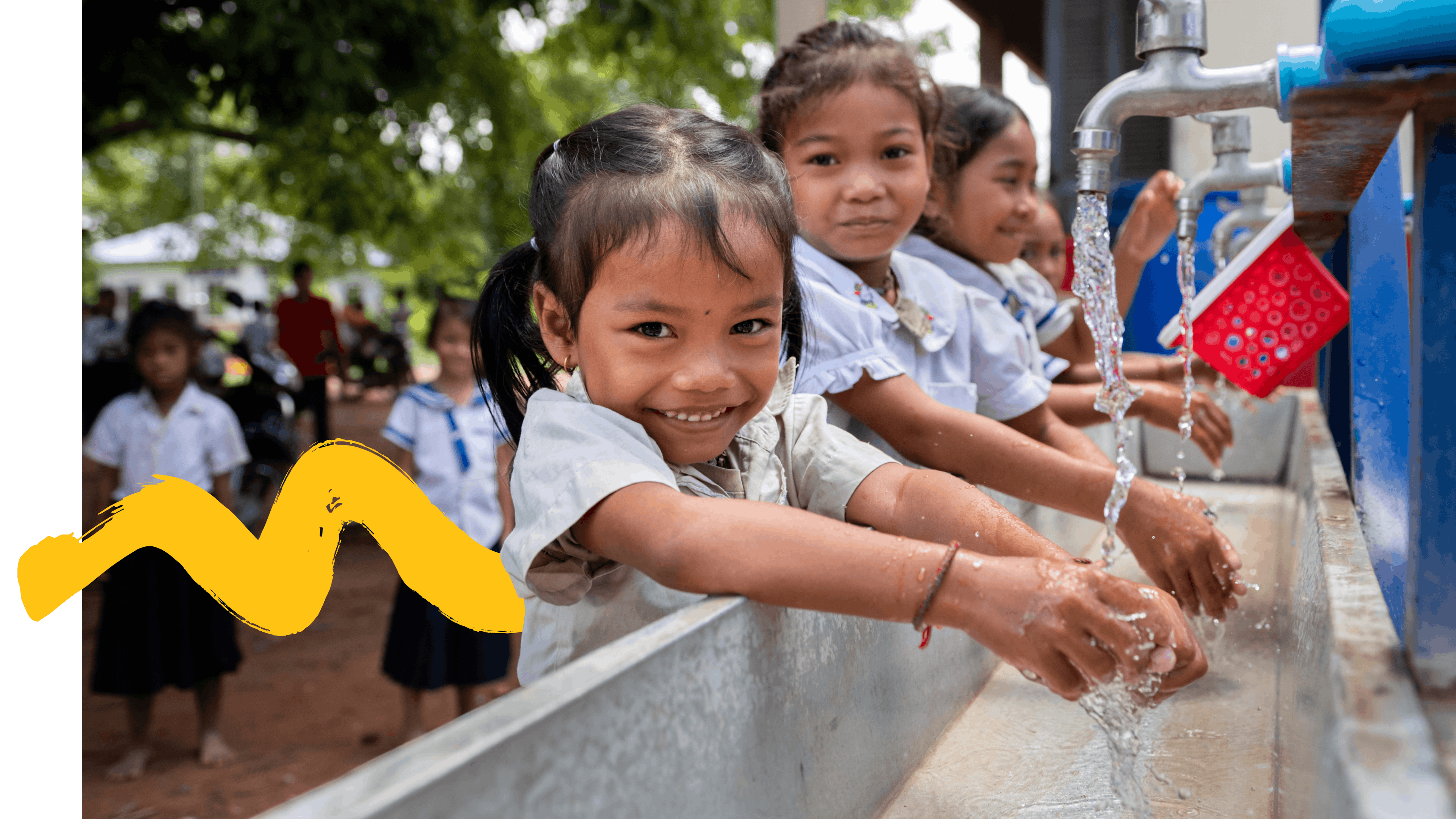 On 26th June 2024, Kim Sovantei (left), 6, and Tin Chantha, 6, wash their hands with other students at the newly installed Water, Sanitation and Hygiene (WASH) station at Sre Chhouk Primary School in Sre Chhouk Village, Rolous Meanchey Commune, Sambo District, Kratie Province, Cambodia.