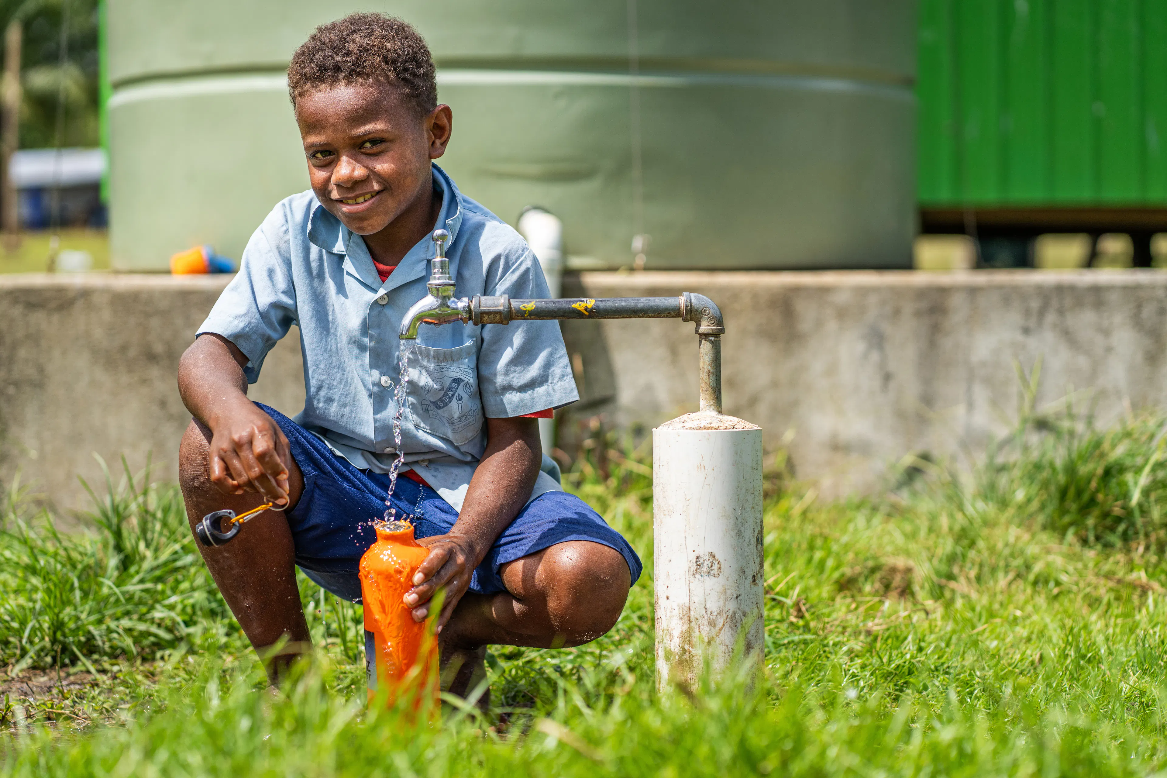 A student fills his water bottle from a UNICEF-supported water supply installation at Areatakiki Primary School in Guadalcanal, Solomon Islands. 

