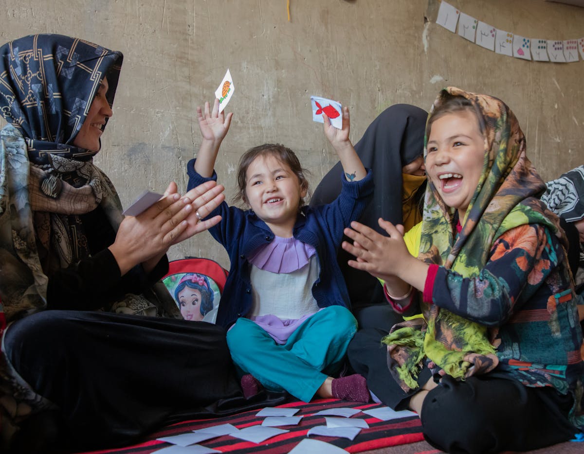 Nargis, 5 and Zahra 8 years old playing with cards with their mother Hamidah