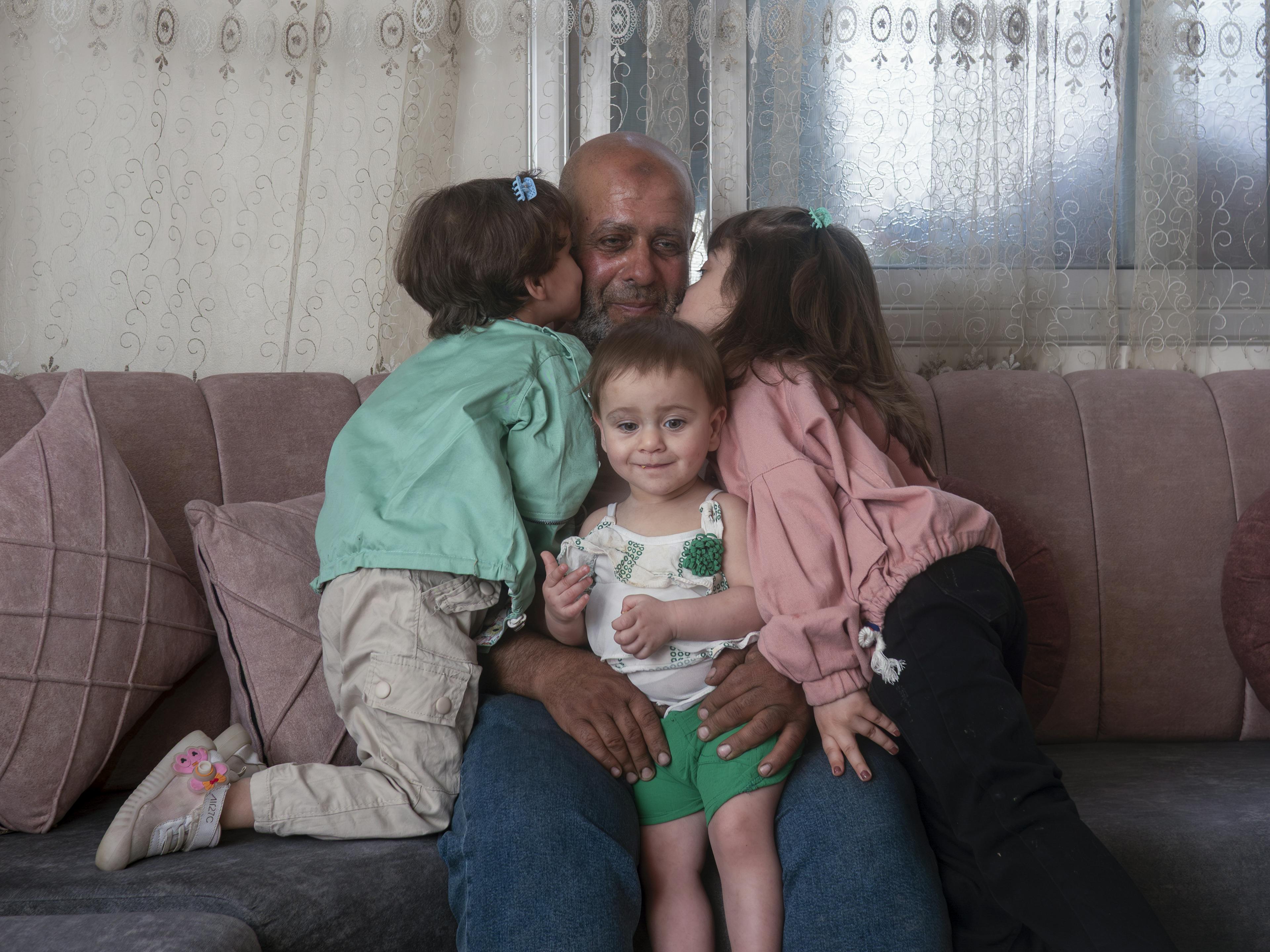 Abu Maher, 54, with his daughters Aline, 5, Lareen, 3, and Haneen, 1, at their home in Duma, Rural Damascus, Syria