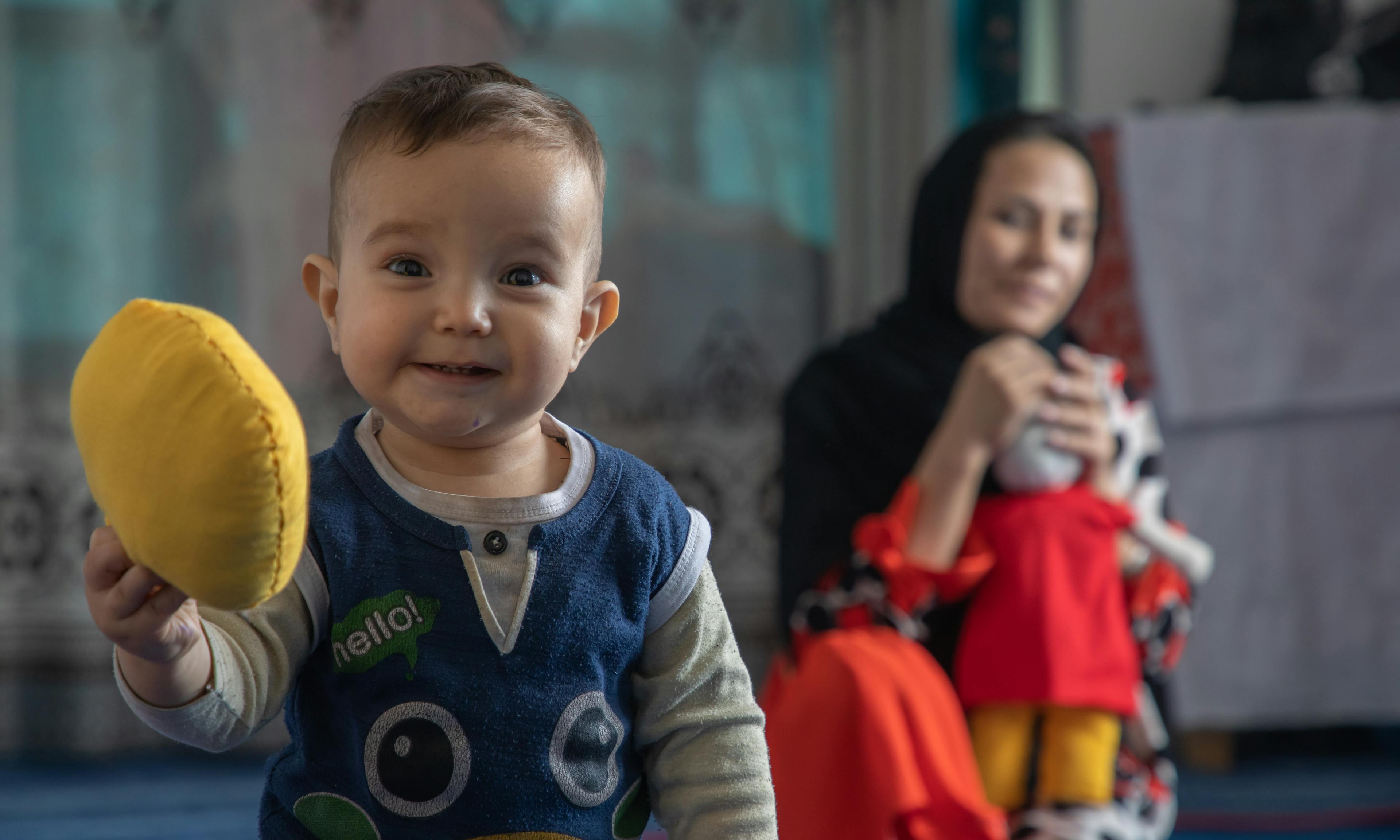 Nahid, 5 and Ali Mehran, 1 year old, are playing with the dolls at their home in Afghanistan
